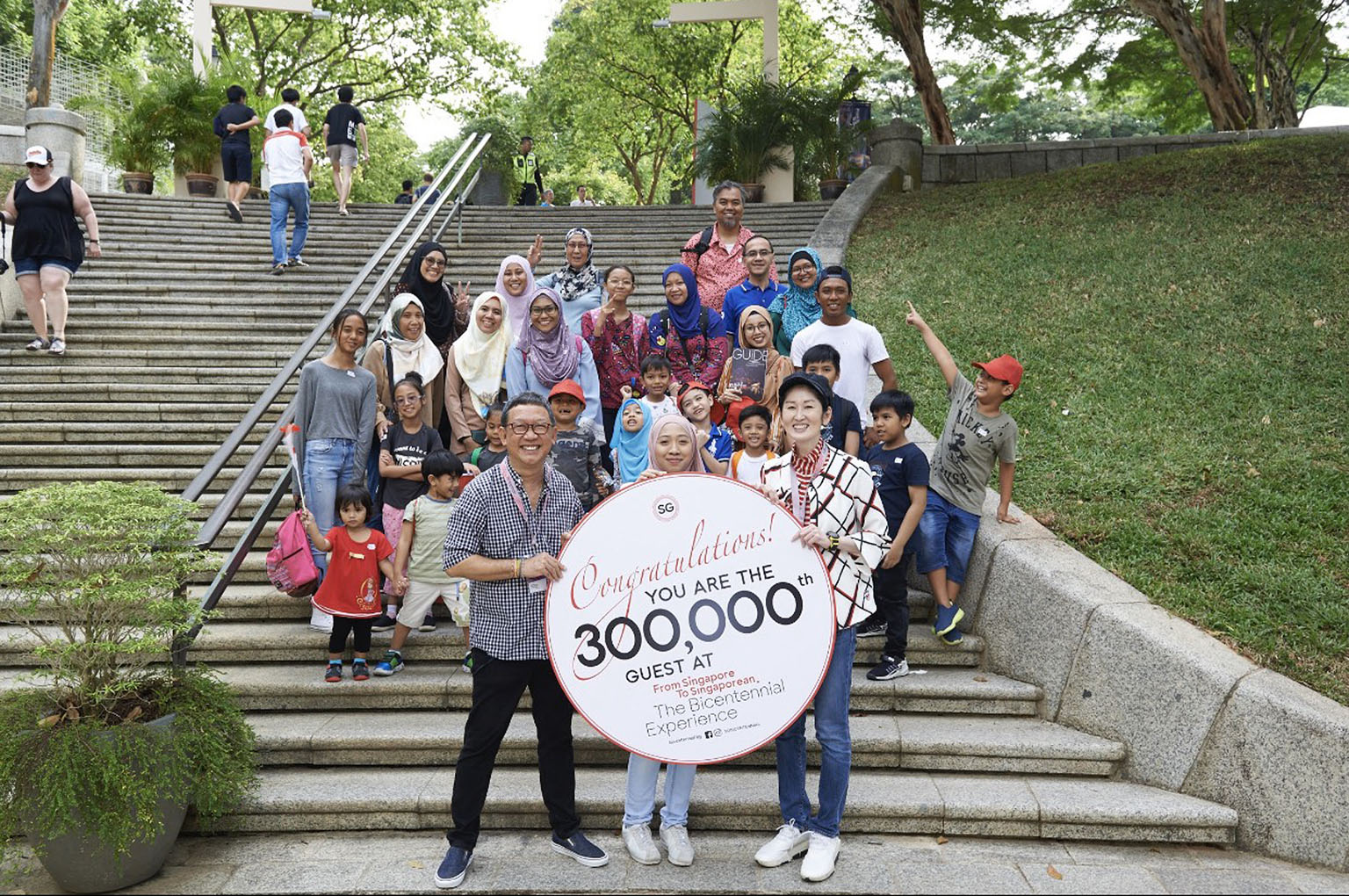 (Front row, from left) Mr Michael Chiang, one of the show's creative directors, the show's 300,000th visitor Qazzira Kamaluddin, and Singapore Bicentennial Office's executive director Gene Tan at Fort Canning.