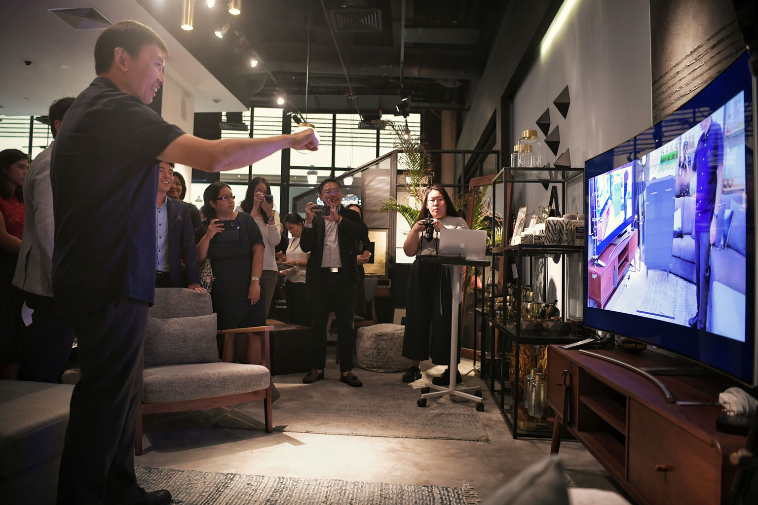Senior Minister of State for Trade and Industry Chee Hong Tat trying out augmented reality technology on his visit to furniture store Commune at Millenia Walk yesterday.