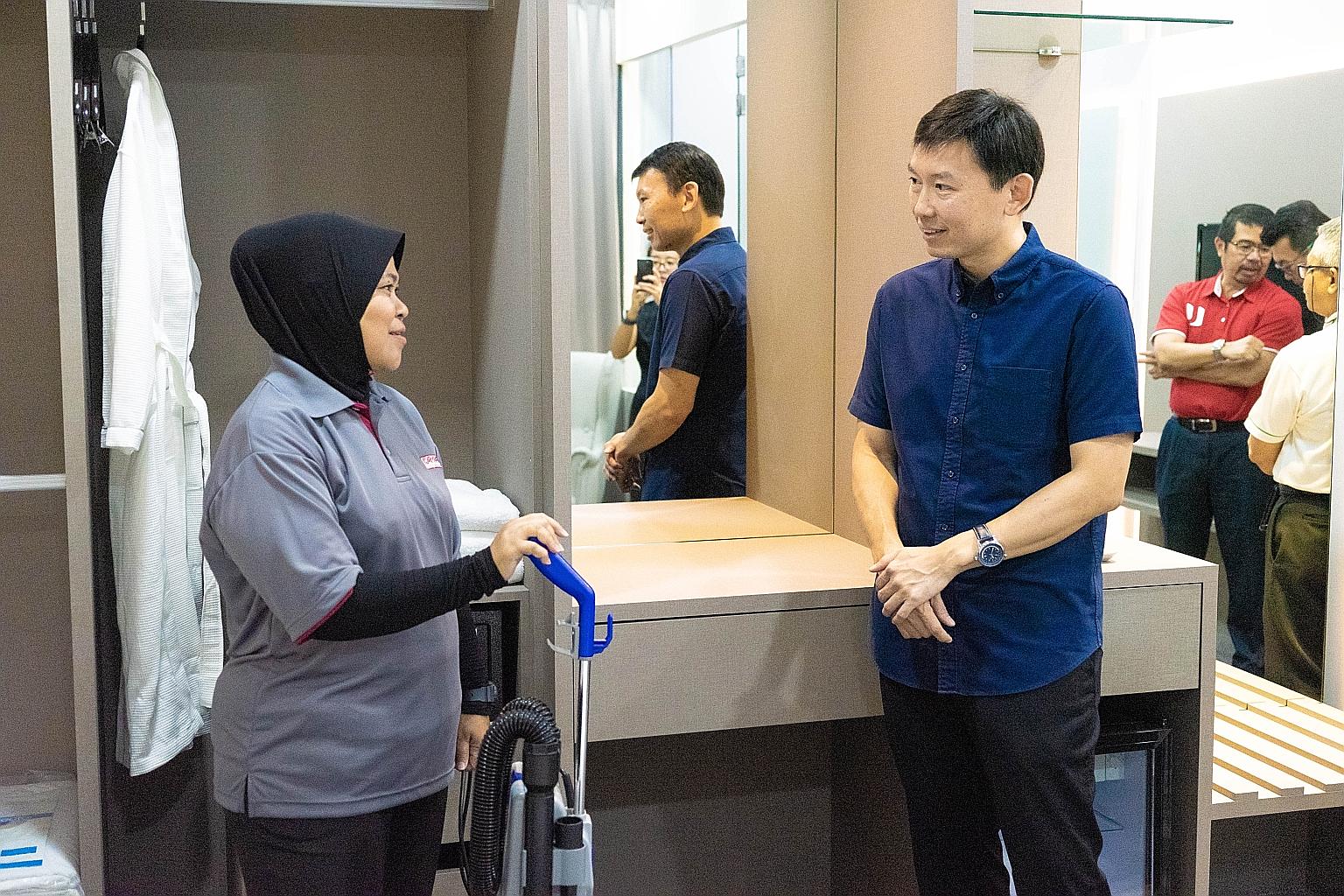 Senior Minister of State for Trade and Industry Chee Hong Tat speaking with a WIS Holdings staff member, who will be trained in housekeeping, at a mock hotel room set up in the company's training academy for environmental services workers.