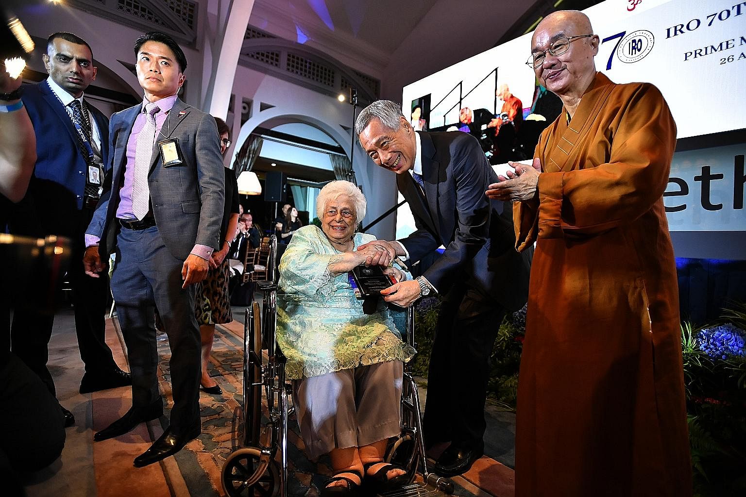 Prime Minister Lee Hsien Loong presenting an award yesterday to Mrs S R Nathan for her husband, the late president S R Nathan, for his efforts in promoting religious harmony. With him was Venerable Kwang Phing (far right), president of Singapore's In