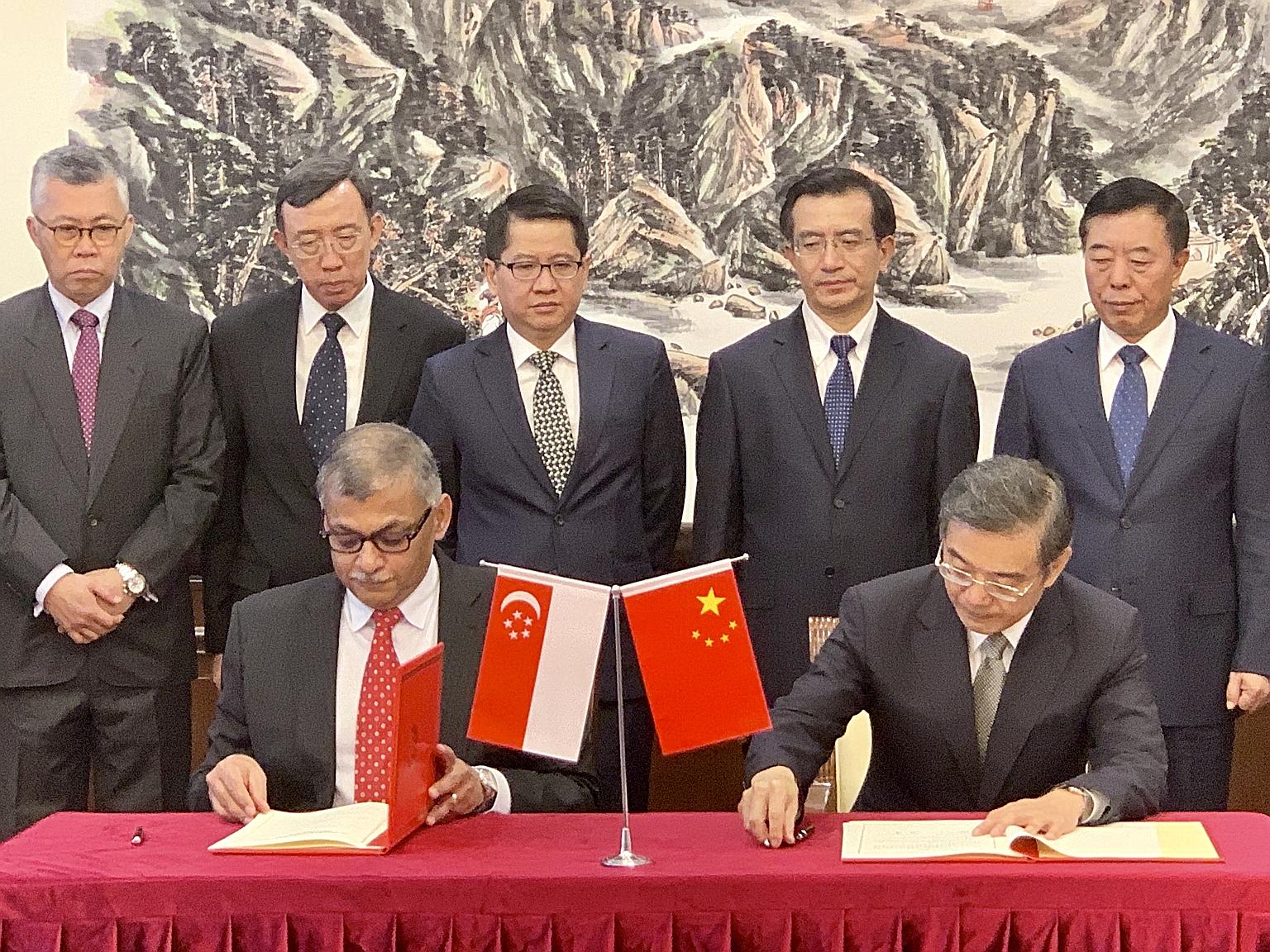Singapore Chief Justice Sundaresh Menon and his Chinese counterpart Zhou Qiang signing the MOU in Beijing yesterday, witnessed by (from left) Singapore's Justices of Appeal Steven Chong and Andrew Phang, Ambassador Stanley Loh as well as China's Supr