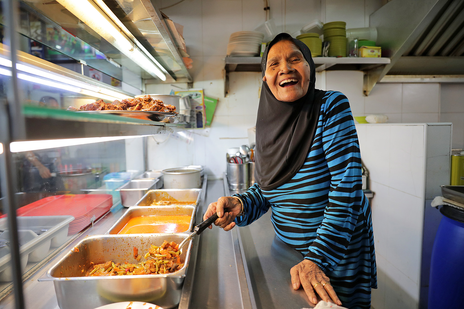 Madam Rosmah Nidar supervises the all-important balance of spices at Che' Rose Nasi Padang in Lorong 1, Toa Payoh, which is run mainly by her son and daughter. Though she is unable to stand for long periods of time, she helps out at the stall every d