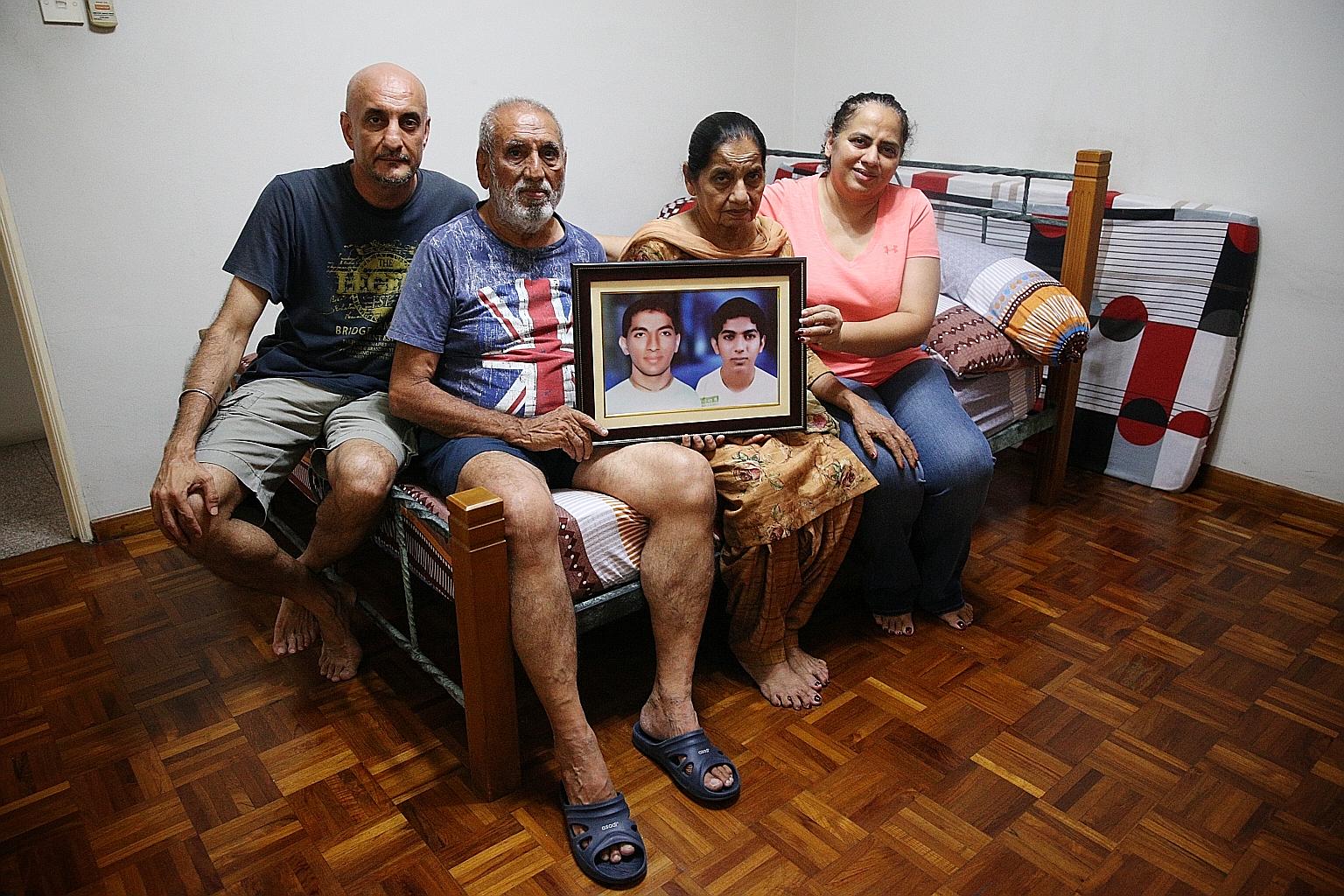 Family members of Dr Sunil Singh Sandhu, (from far left) Mr Ramesh Singh, Mr Sojit Singh, Ms Jasbir Kaur and Ms Geetajeet Kaur Sandhu, posing with his portrait in Dr Sunil's bedroom in their home in Geylang last Thursday. ST PHOTO: JASON QUAH