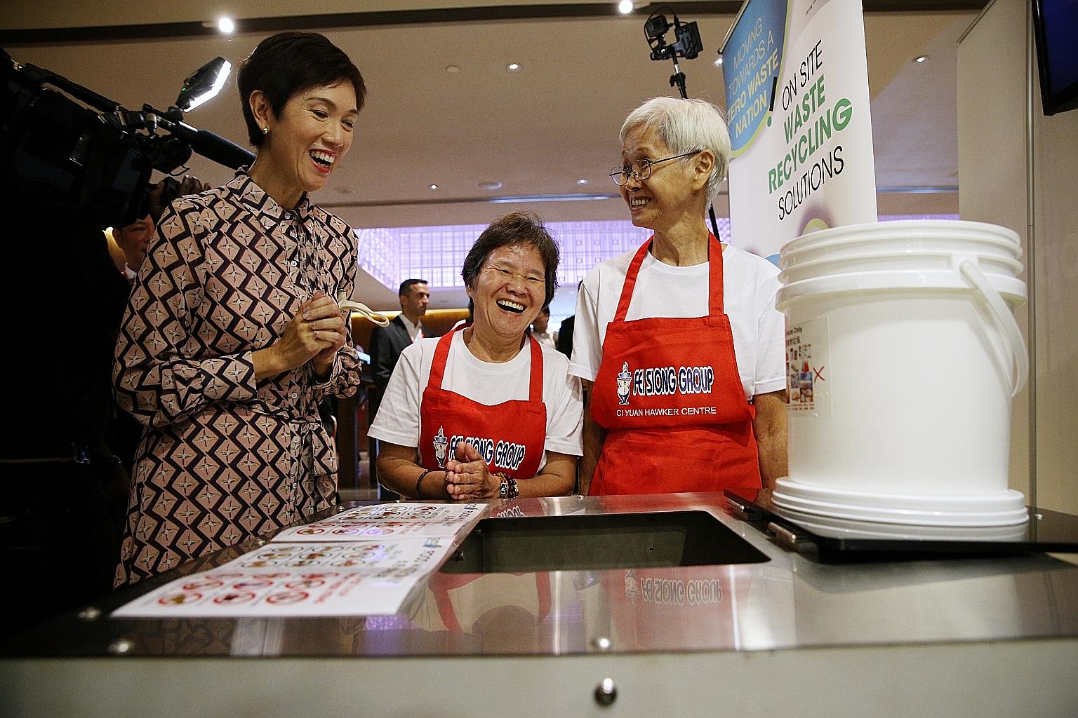 (From left) Manpower Minister Josephine Teo chatting with Madam Ong Poh Kee, 57, and Madam Chua Cher Kee, 75, both cleaning ambassadors at Fei Siong, about an eco-digester that turns food waste into water and carbon dioxide and helps lighten cleaning