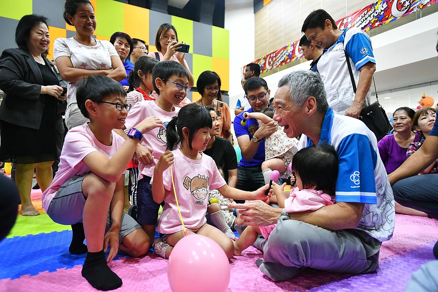 Prime Minister Lee Hsien Loong with (from left, in pink) siblings Caleb Ng, 11; Joshua Ng, eight; Chen Nuo, eight; and 13-month-old Clara Ng (in his lap) at the Embracing PArenthood Celebration at Teck Ghee Community Club yesterday. PM Lee is the MP