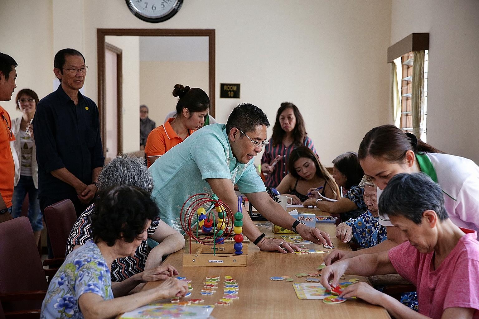 Senior Minister of State Maliki Osman (in light green), Orange Valley Nursing Homes chief executive Lyn Edel Yip (in orange) and Singapore Press Holdings' Mr Seow Choke Meng (left), business consultant, Chinese Media Group and Times Properties, with