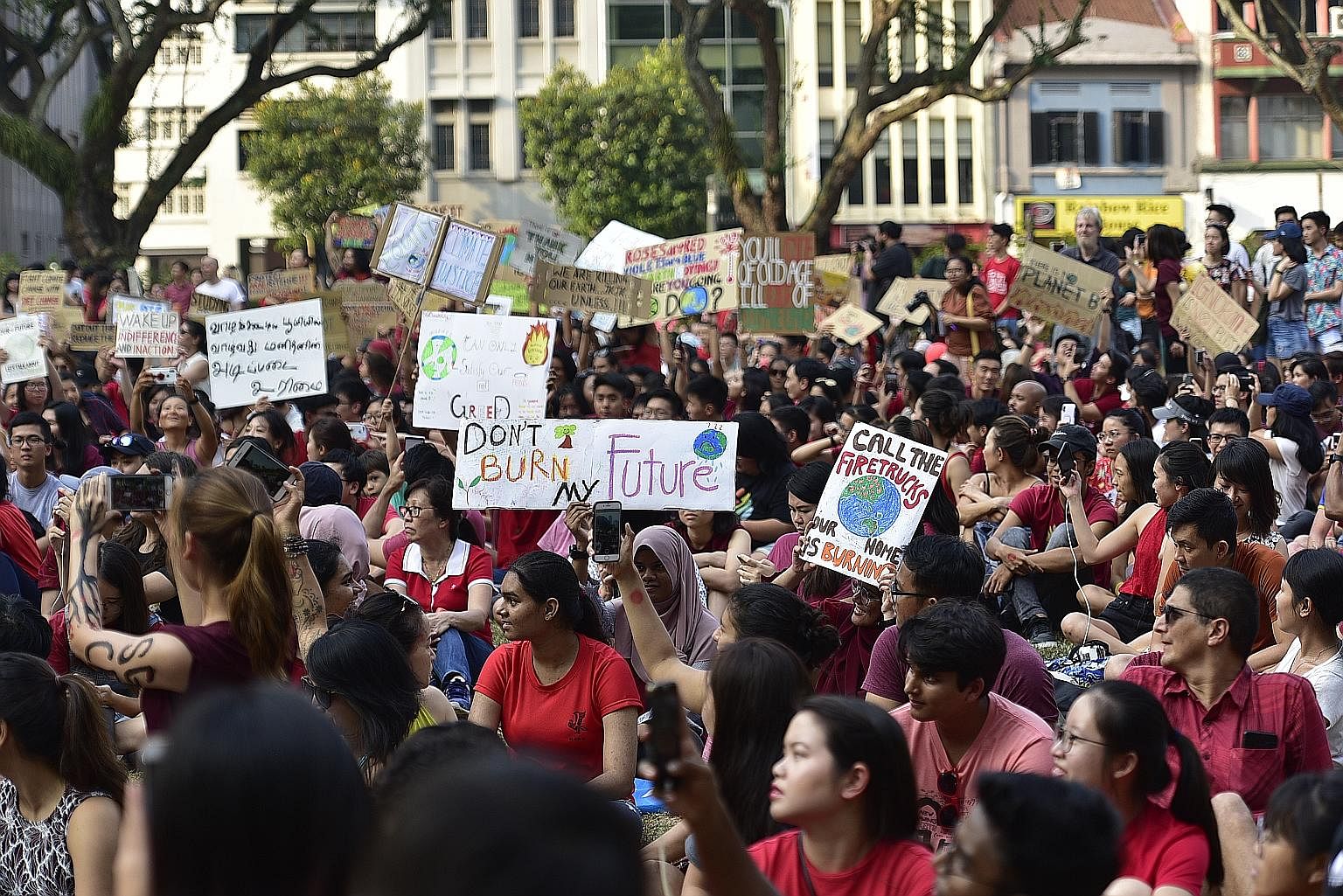 Participants rallying for more action on climate change at Hong Lim Park yesterday. Clad in red for the rally, they held up banners, such as "no planet B", "no beer on a dead planet", "respect your mother (earth)" and "I stand for what I stand on", a