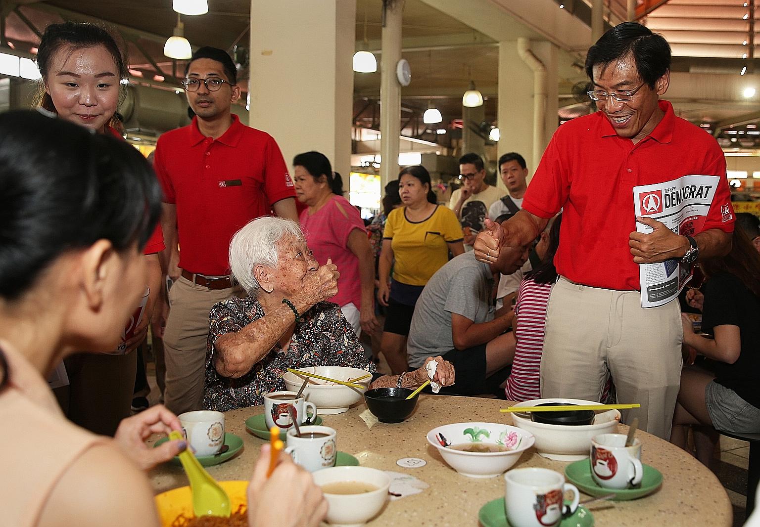 Singapore Democratic Party's Dr Chee Soon Juan and an elderly resident giving each other the thumbs up during his walkabout in Yuhua with party members on Aug 4. SDP plans to launch its manifesto soon and hold a pre-election rally next month.