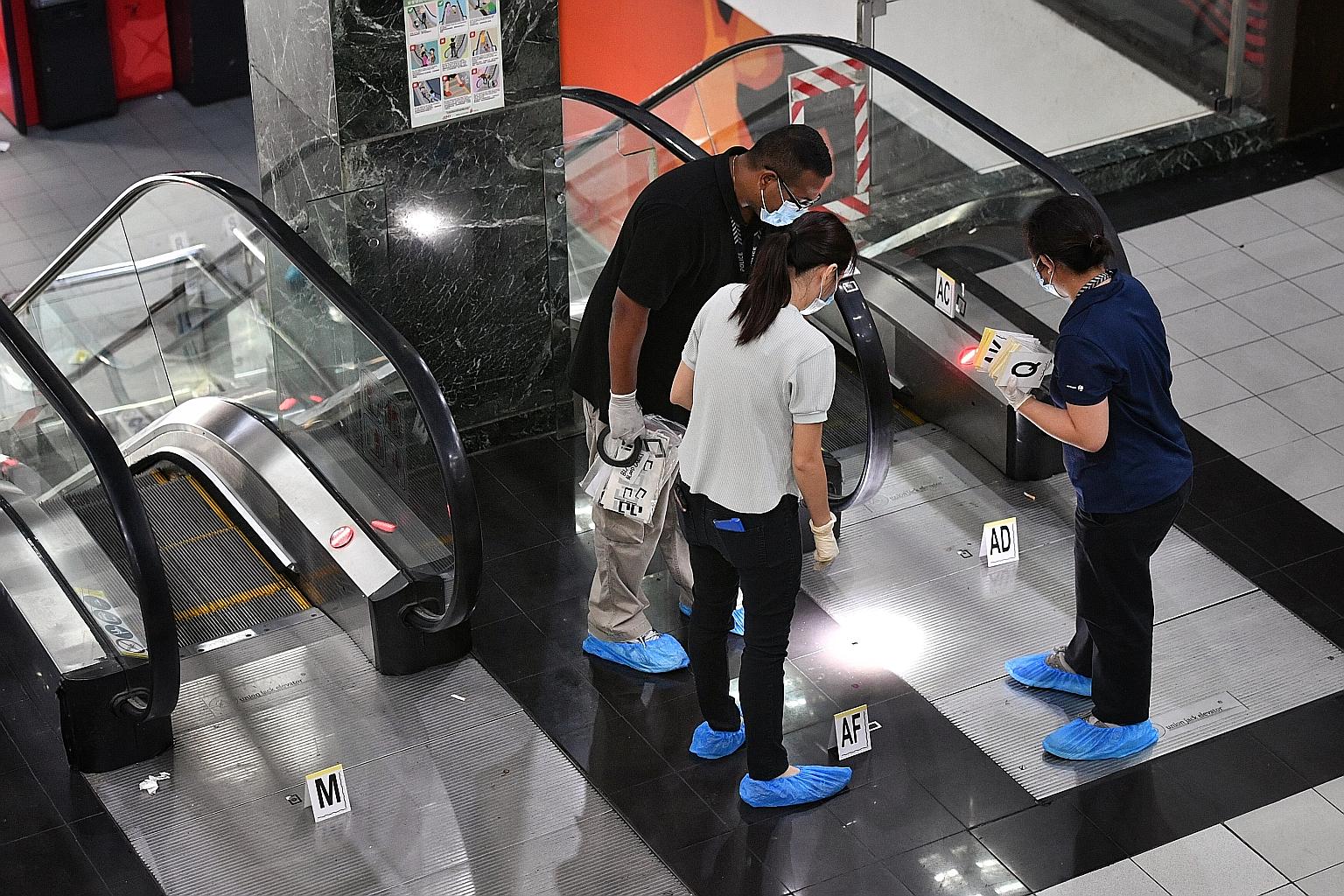 Investigators at the scene of the Orchard Towers murder. Tan Hong Sheng, who jumped bail last month, was arrested on Thursday. Yesterday, Tan was also served with an unrelated rioting charge.