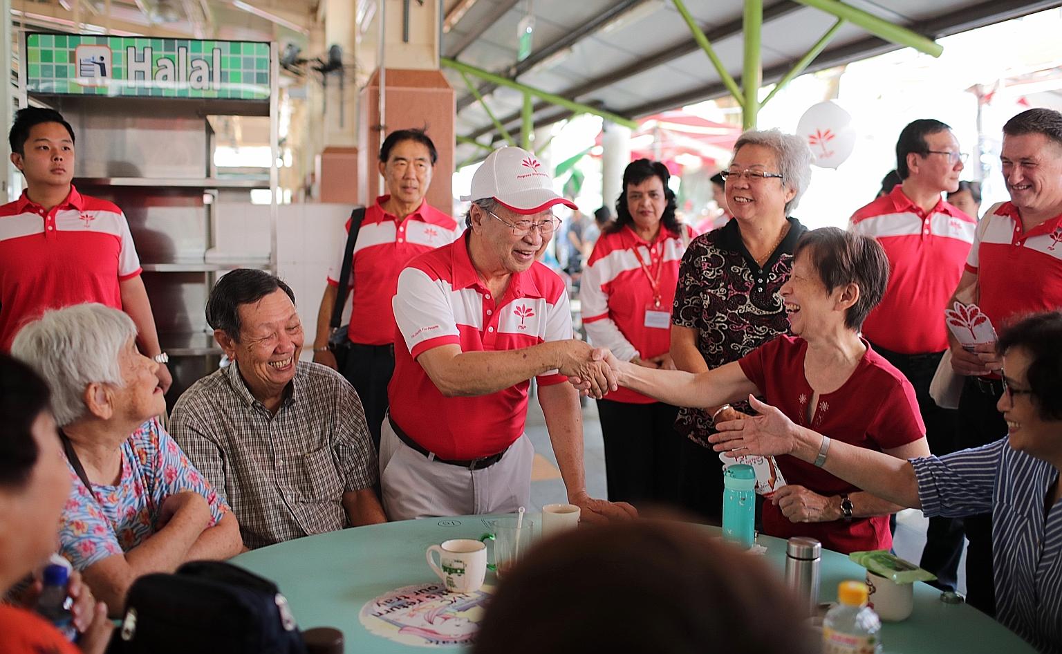 Progress Singapore Party secretary-general Tan Cheng Bock greeting people at Ghim Moh Market and Food Centre yesterday. About 300 party members and volunteers visited all 29 constituencies across the island.