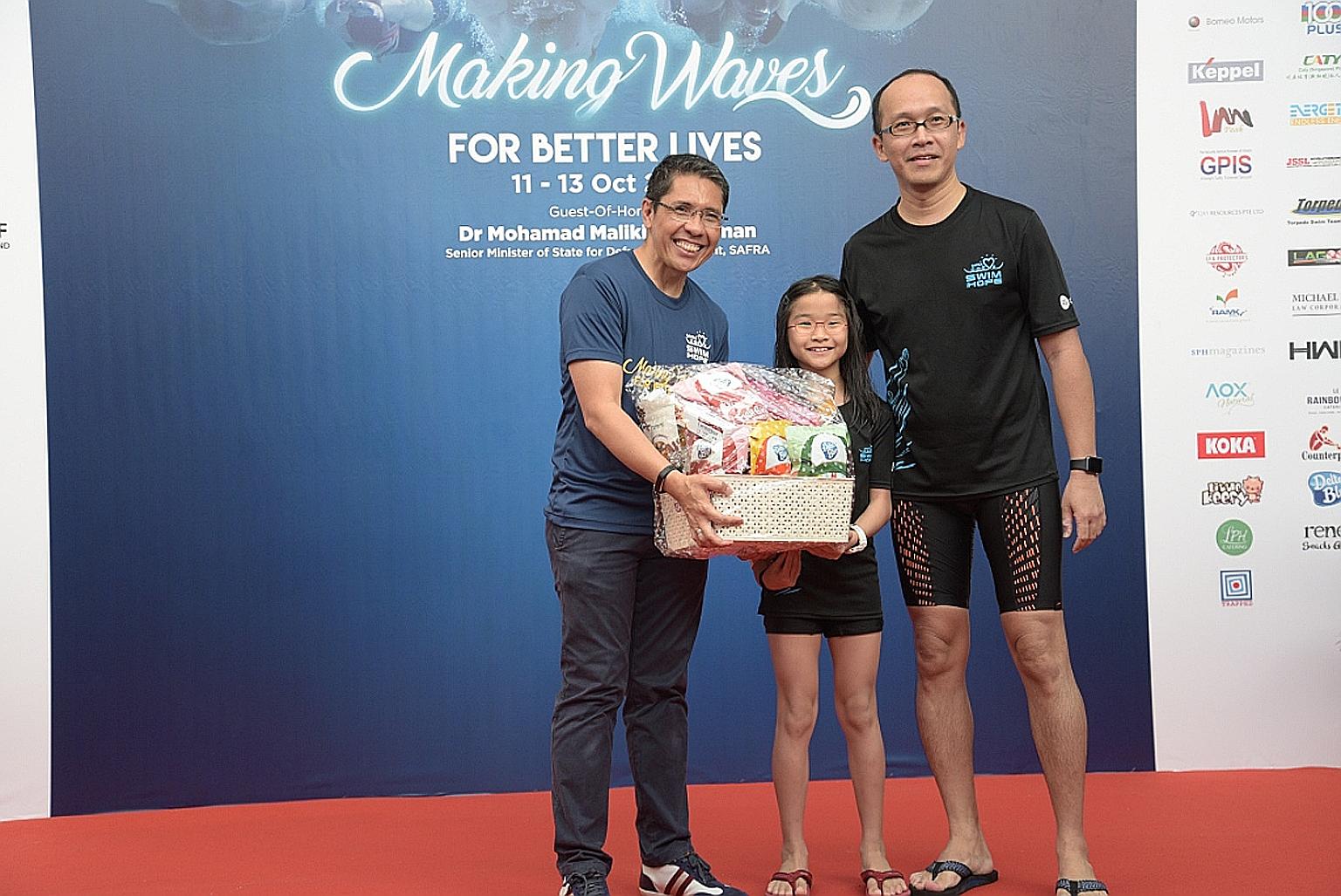 Safra president Maliki Osman presenting a hamper yesterday to Mr Ong Chin Hwee and his 10-year-old daughter Wen Yi, who finished as runners-up in the Families for Life category of the Safra Swim for Hope event.