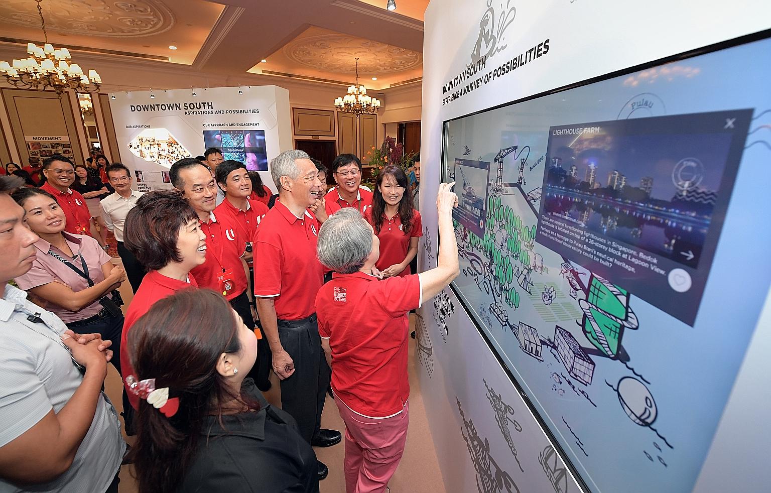 Prime Minister Lee Hsien Loong and his wife, Mrs Lee, viewing the Downtown South display with other guests at the NTUC National Delegates' Conference at Orchid Country Club yesterday.