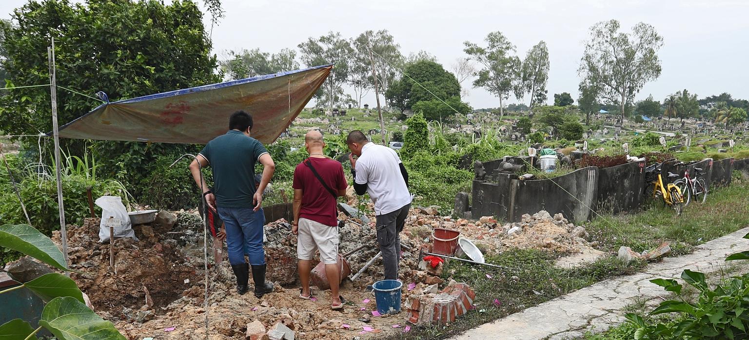 National Environment Agency workers conducting exhumations at Choa Chu Kang Chinese Cemetery. The agency said this is the first time it has encountered this misalignment issue in the 16,800 exhumations conducted as of Sept 30 under Phase 7 of its exh