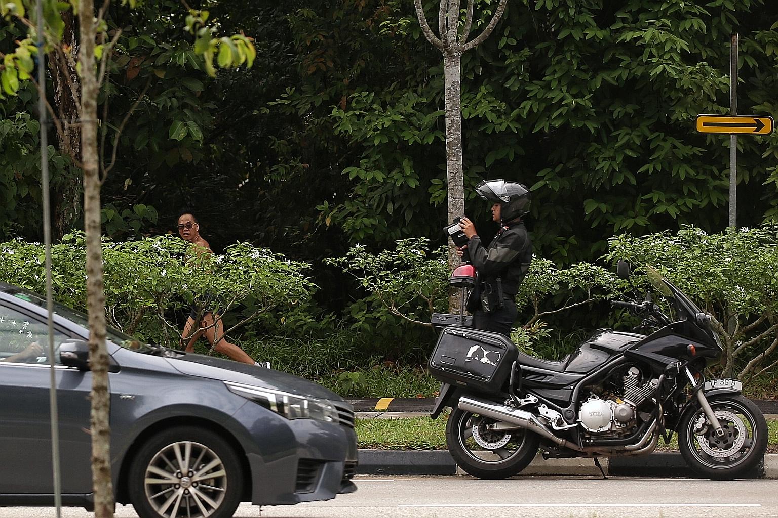 A Traffic Police officer monitoring traffic speed in Mandai Road during an enforcement operation yesterday.