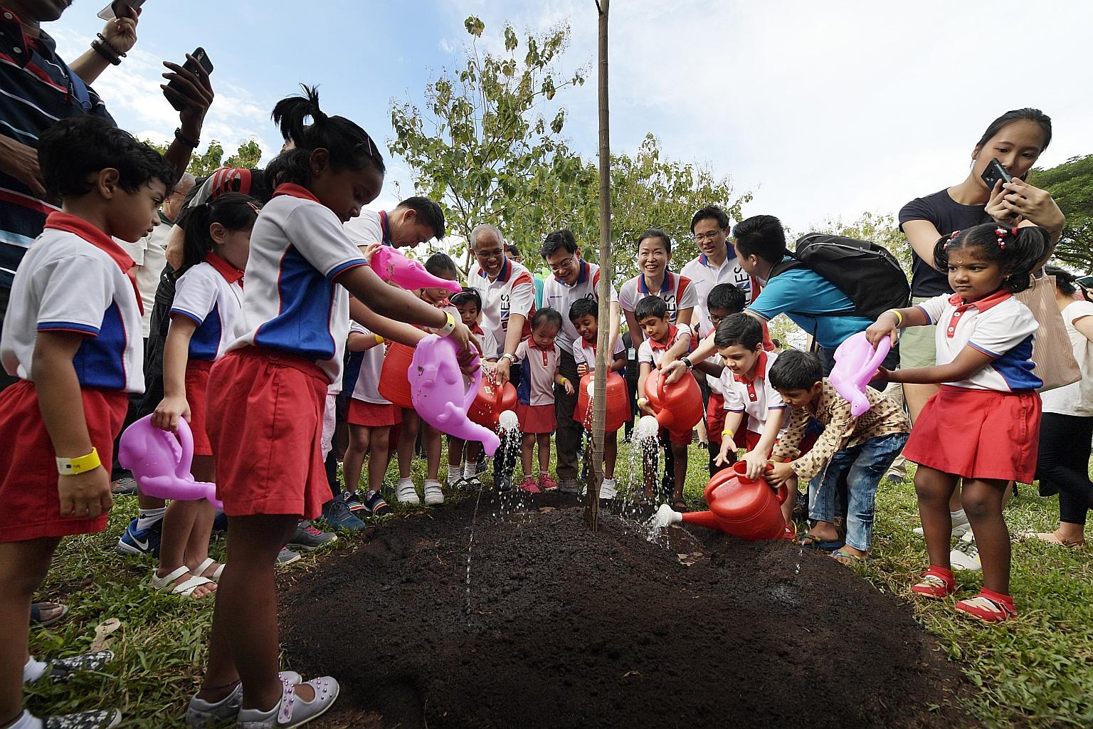 Pupils from PAP Community Foundation (PCF) Sparkletots planting a terap tree together with (centre, from left) Senior Parliamentary Secretary for Culture, Community and Youth, and Transport Baey Yam Keng; Minister for the Environment and Water Resour