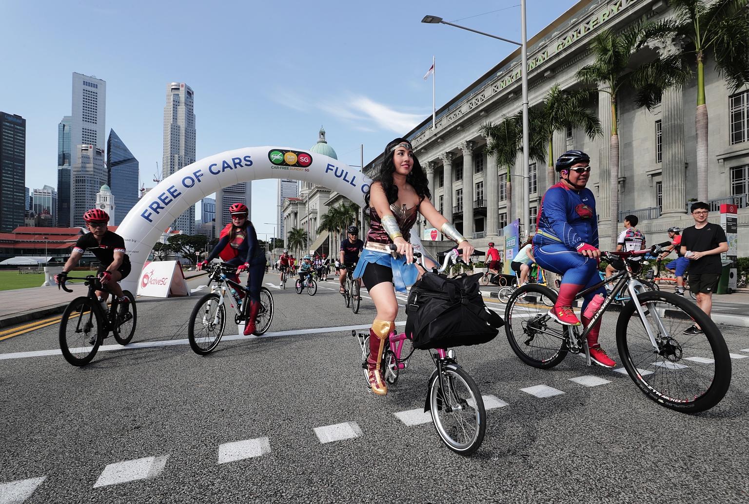 Madam Mow Lai Lin (second from left), dressed as Superwoman, with other cyclists also in superhero costumes at Car-Free Weekend yesterday. The group cycled from Stadium MRT station to Marina Bay Sands and then to the Padang.