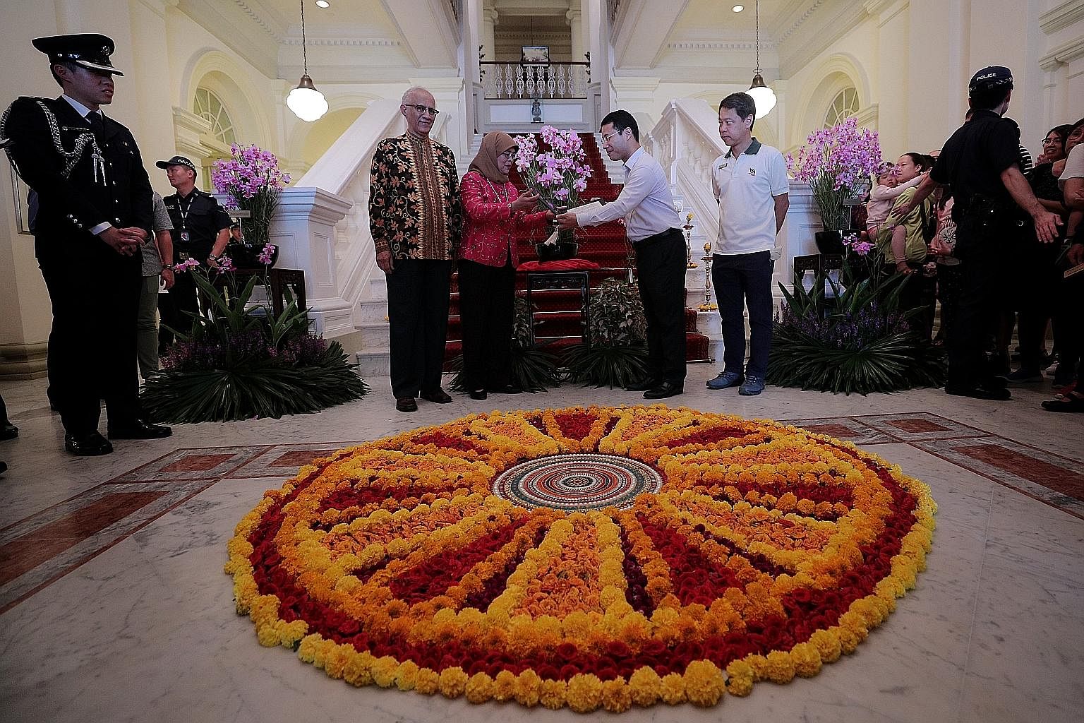 President Halimah Yacob unveiling the new Bicentennial Orchid at the Istana yesterday with Second Minister for National Development Desmond Lee, who is also Minister for Social and Family Development. They are flanked by Madam Halimah's husband, Mr M