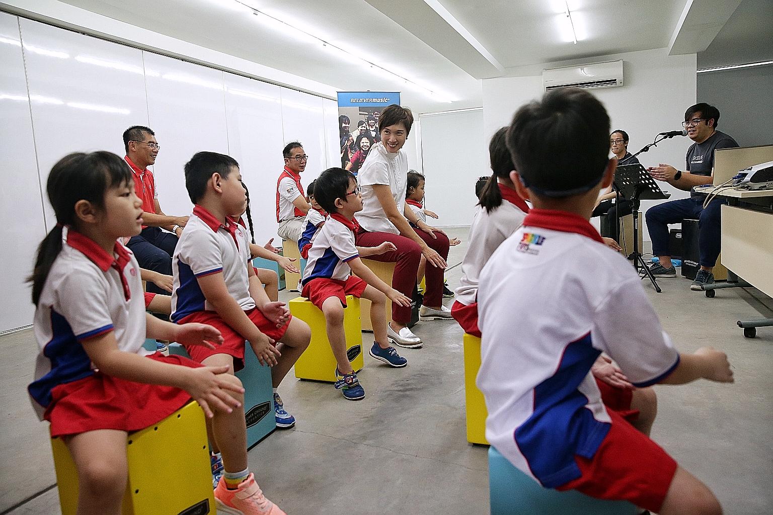 Manpower Minister and PAP Community Foundation (PCF) executive committee chairman Josephine Teo joining PCF Sparkletots Kindergarten 2 children taking part in a Cajon class at Goodman Arts Centre yesterday. ST PHOTO: KEVIN LIM