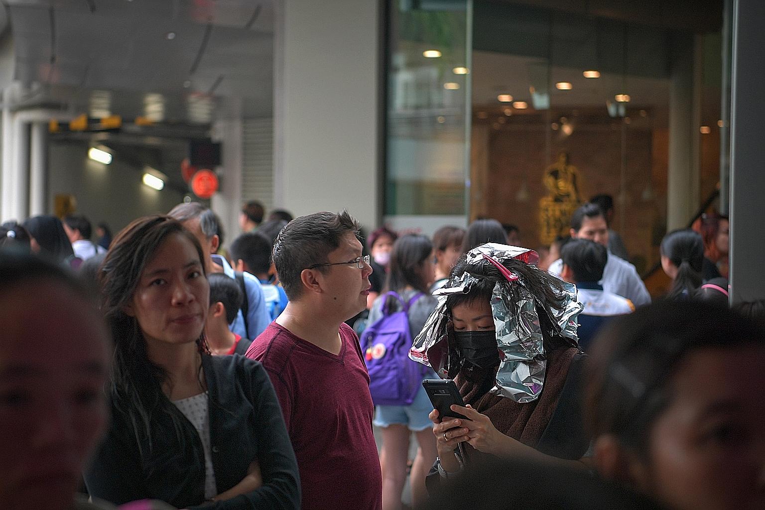 About 4,000 people, including this woman who was having her hair done at a salon, were evacuated from Century Square mall in Tampines after a fire broke out in its foodcourt yesterday. The Singapore Civil Defence Force (SCDF) responded to the fire, w