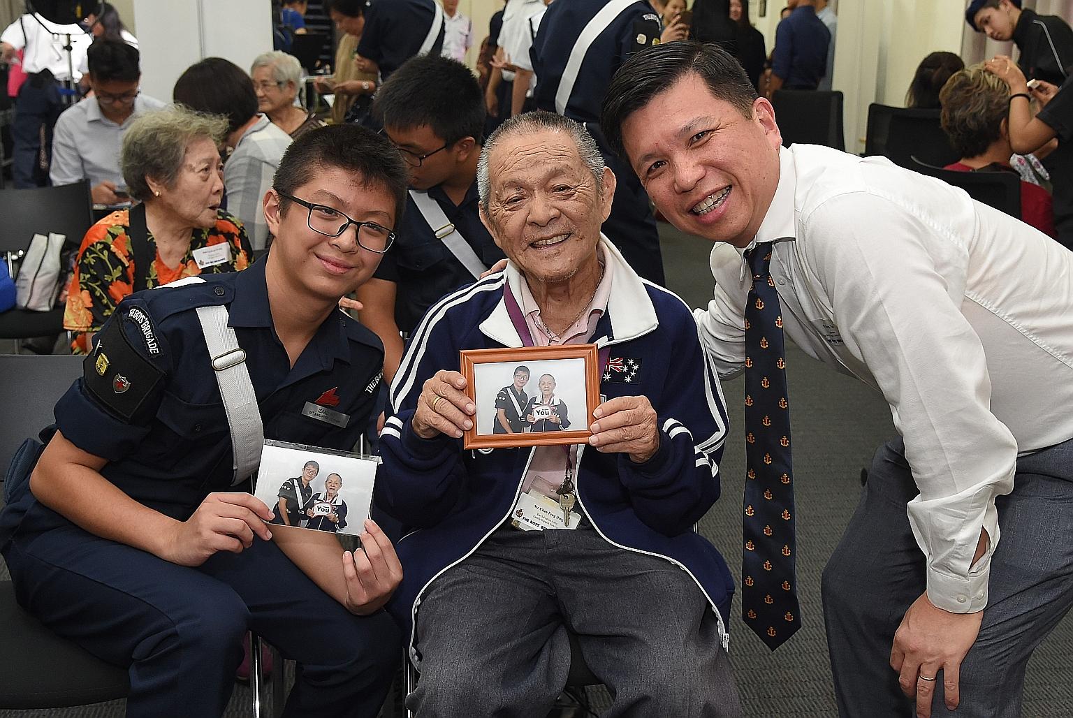 Boys' Brigade Share-a-Gift 2019 chairman Henry Tan with Boys' Brigade member Isaac Ho and Mr Chan Peng Hing, a senior from The Salvation Army Family Support Services, who was invited to yesterday's media conference. Mr Chan is holding a photograph of