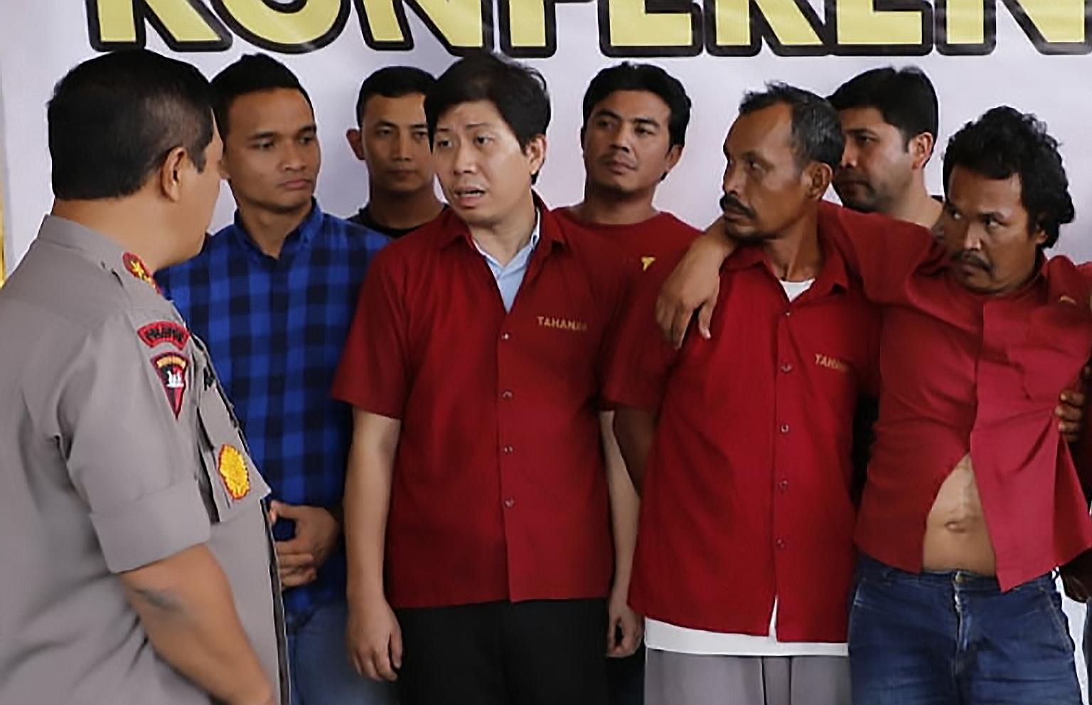 North Sumatra police chief Agus Andrianto on Friday questioning suspects (in red) in connection with the deaths of two journalists. Among those arrested was businessman Wibharry Padmoasmolo.