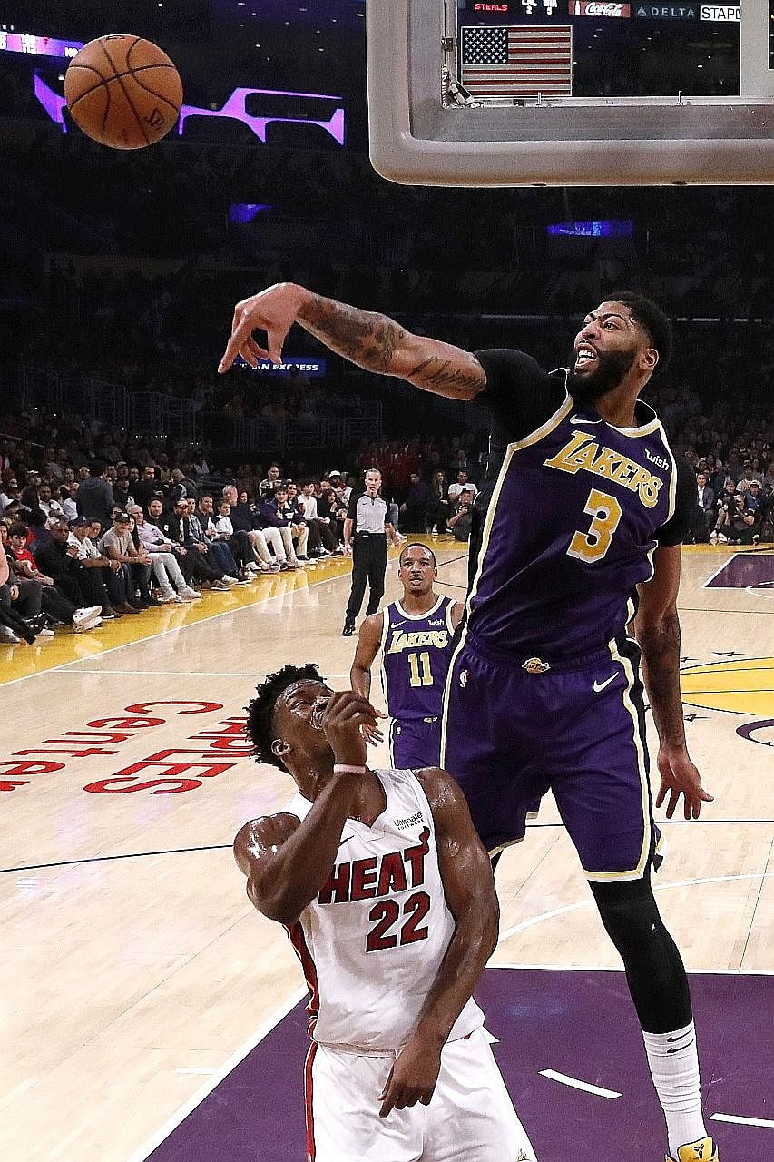 LA Lakers' Anthony Davis blocking a shot by Miami Heat's Jimmy Butler during the Lakers' 95-80 victory at the Staples Centre in Los Angeles on Friday. Davis finished with a team-leading 26 points and eight rebounds. PHOTO: AGENCE FRANCE-PRESSE