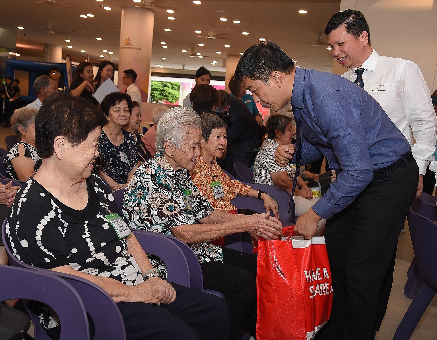 Speaker of Parliament Tan Chuan-Jin distributing food hampers to elderly beneficiaries at the launch of the 2019 Boys' Brigade Share-a-Gift charity drive at Our Tampines Hub.