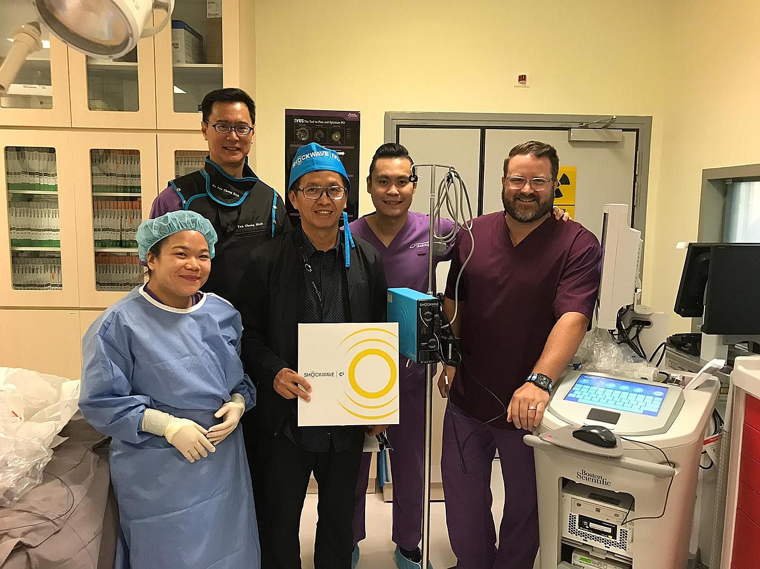 Dr Tan Chong Hiok (second from left), a cardiologist at Mount Elizabeth Hospital, has treated three patients using the new intravascular lithotripsy (IVL) device. With him are (from left) staff nurse Koo Suet Teng and cardiologist Chuang Hsuan Hung f