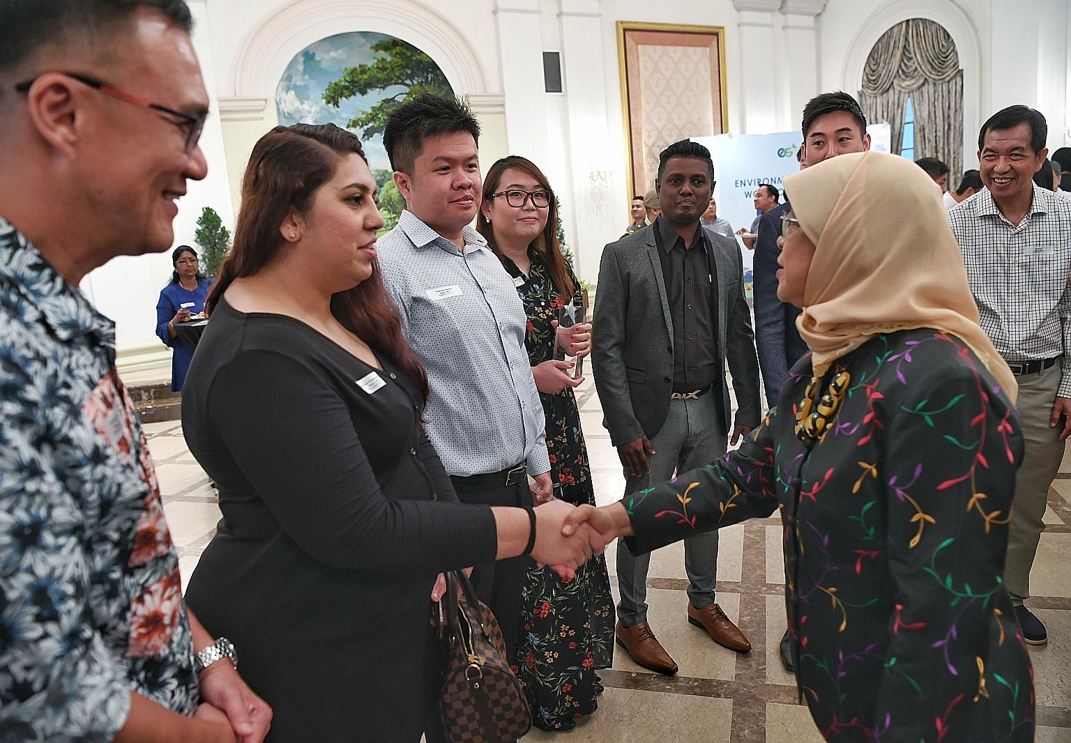 President Halimah Yacob meeting guests and award winners - including Ms Regina Cheah (fourth from left), who received an Environmental Services Star Award - at the Istana yesterday.
