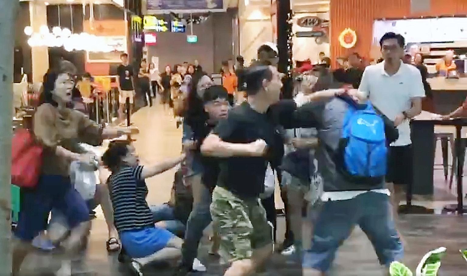 A screengrab of a video showing about 10 people, including women, involved in the brawl in front of fast-food chain A&W at Jewel Changi Airport on Sunday. PHOTO:
