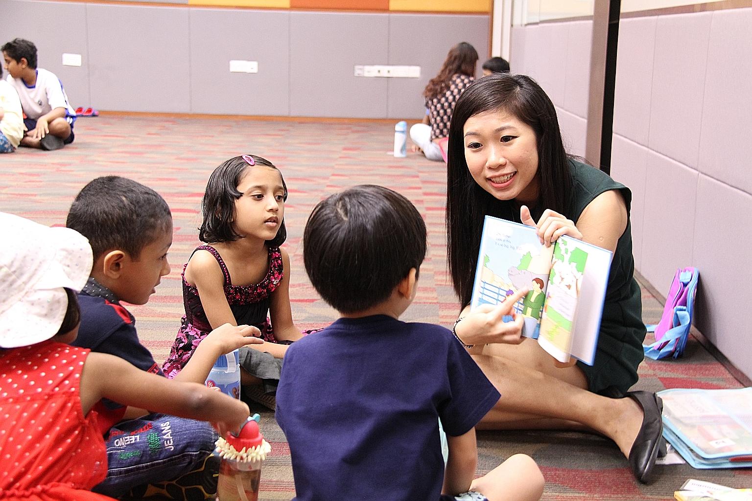 Volunteer Gelien Chia reading to children in Calvary Community Care's literacy support programme Story Lab, where kids attend free weekly reading sessions in small group settings. PHOTO: CALVARY COMMUNITY CARE