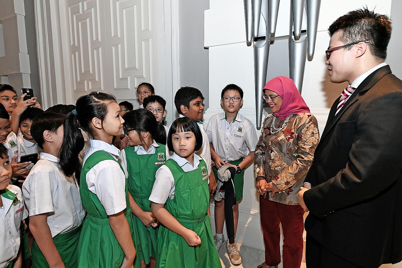 President Halimah Yacob and guitar soloist Kevin Loh meeting Bukit Panjang Primary School pupils at the President's Young Performers concert, held at Victoria Concert Hall in September.