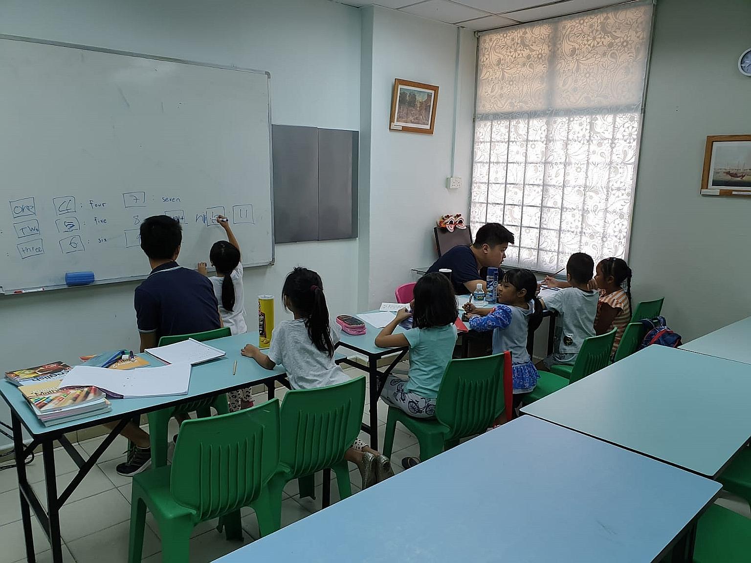 A Budding Minds tuition session in progress at the We Love Learning Centre in Henderson. Mr Chua Tze Hean, who started the project, says the volunteer tutors try to make content more interesting by showing the children real-life applications of their