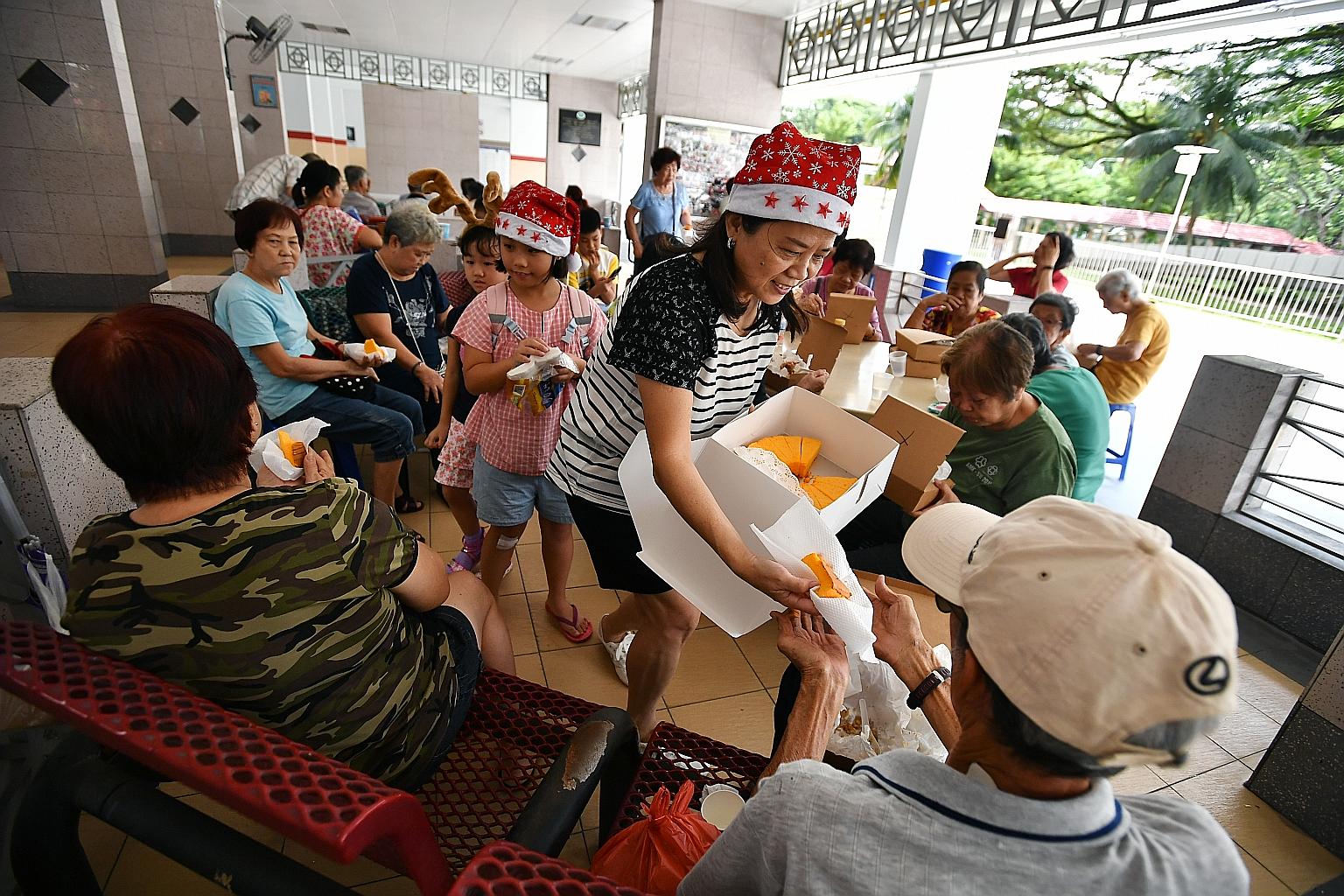 Madam Josephine Koh, 60, serving orange chiffon cake to the elderly in Ang Mo Kio last Wednesday. Apart from befriending seniors, volunteers like her at Living Way Social Services also do free house refurbishment for the elderly and their families, s