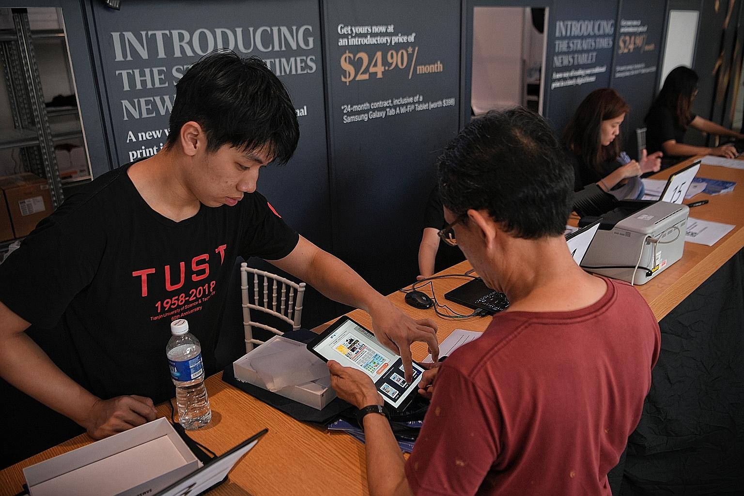 A subscriber collecting his Samsung Tab A 10.1-inch Wi-Fi tablet pre-loaded with the ST app at Plaza Singapura yesterday. Adjustments to the queue system have shortened the waiting time for subscribers collecting their tablets to about 10 to 15 minut