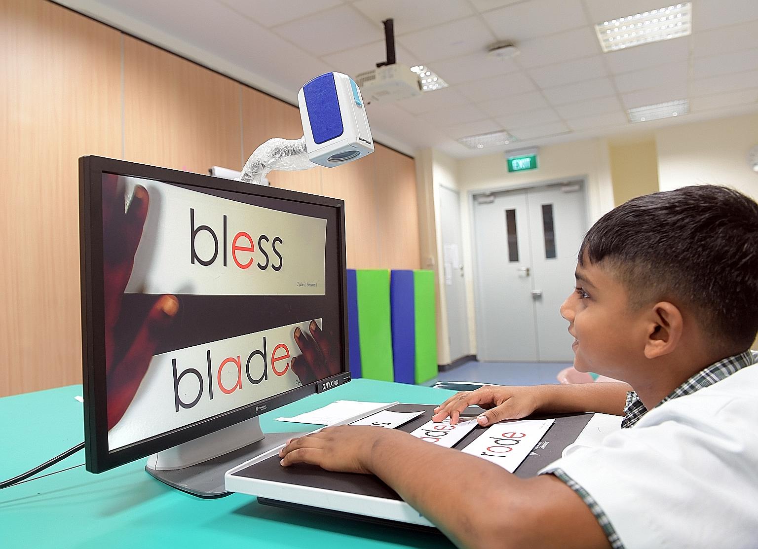 Tejas Mahendran, seven, who has low vision due to cone-rod dystrophy, uses a portable video magnification system that enlarges words on the class whiteboard and materials like worksheets to help him read.