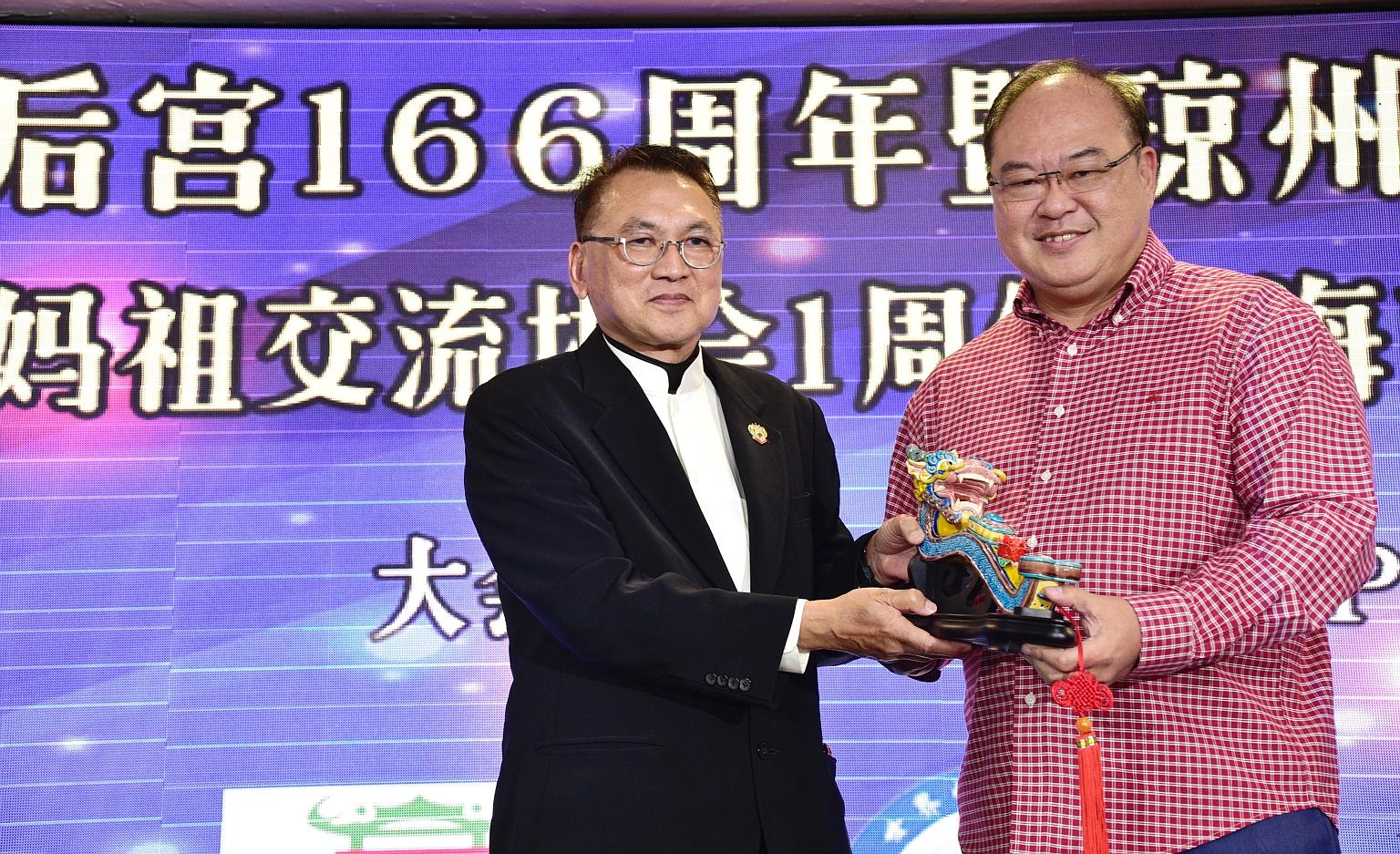 Kheng Chiu Tin Hou Kong and Burial Ground chairman Foo Jong Peng (left) presenting a memento to Mr Tan Aik Hock, president of the Singapore Federation of Chinese Clan Associations, during the launch of the Hainan Federation yesterday.