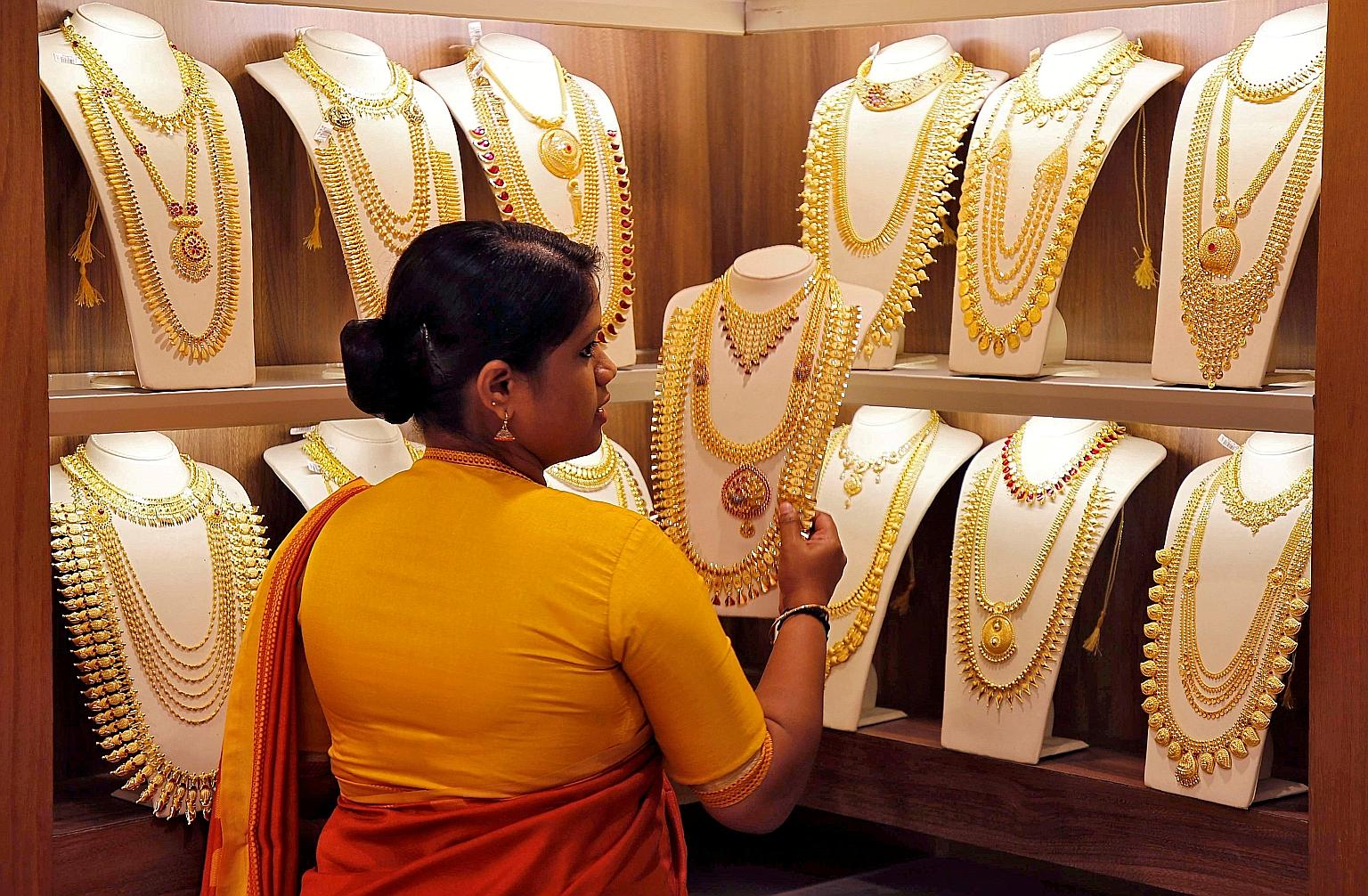 A saleswoman picking gold necklaces to show to a customer at a jewellery showroom in Kochi, India, in May. Spot gold rose 0.3 per cent to US$1,514.97 an ounce as of 1.51pm in New York on Monday, extending its December gain to 3.5 per cent, according