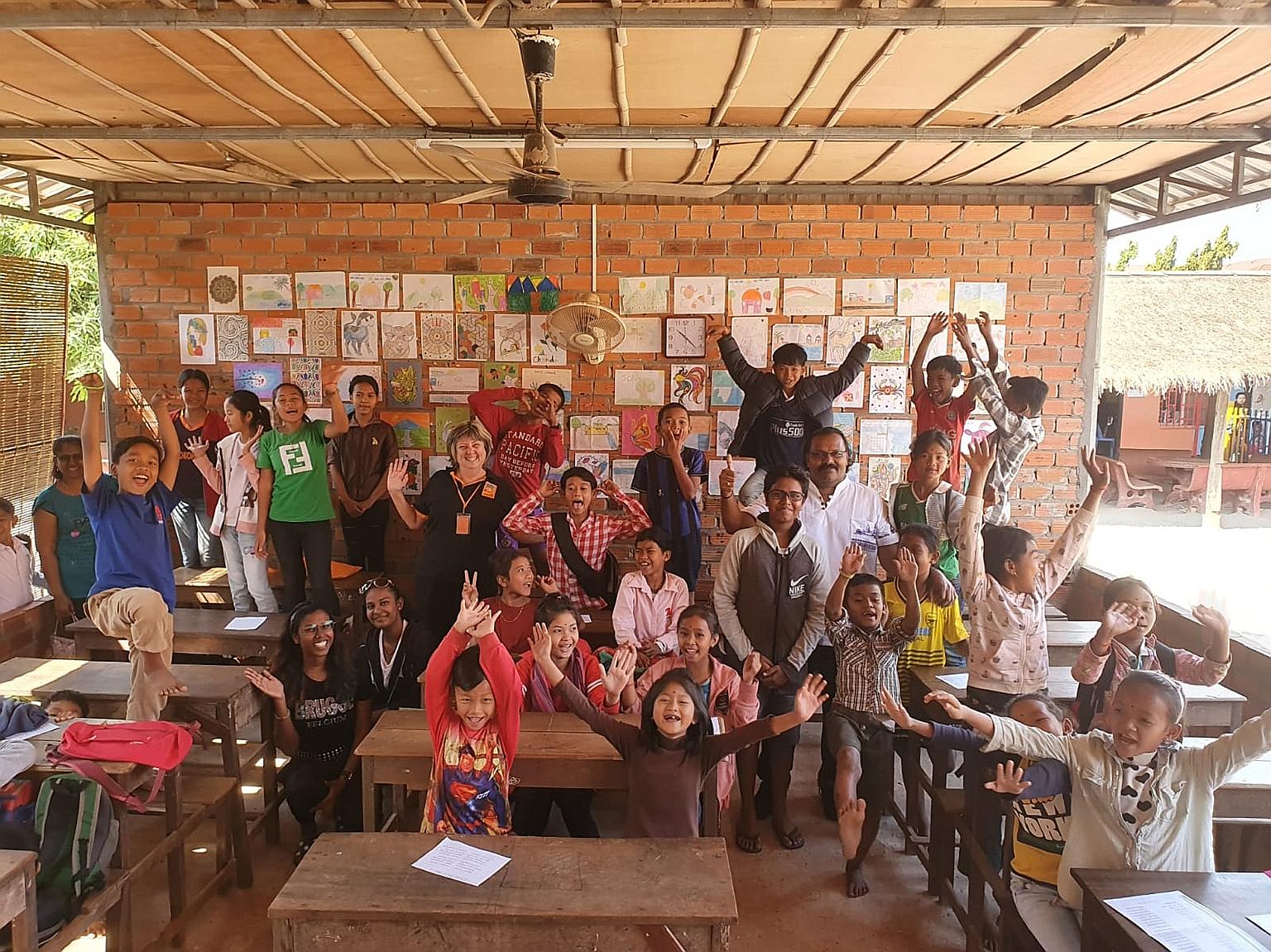 Mr Kevin Raja (in white shirt) and his family with the children and staff of a community school run by non-profit charity Feeding Dreams Cambodia in Siem Reap last month.
