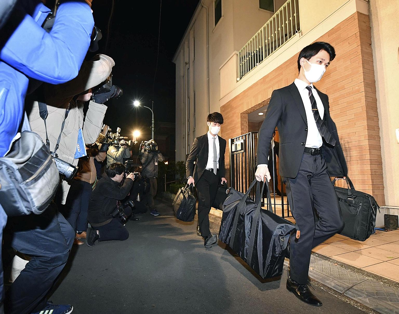 Officials from the Tokyo District Public Prosecutors Office carrying bags out after raiding the Tokyo residence of Carlos Ghosn as part of an investigation into his escape from Japan to Lebanon. NHK said the authorities are expected to analyse securi