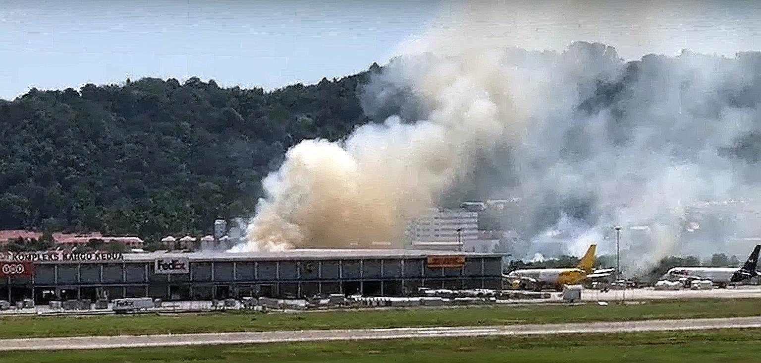 Thick, white smoke billowing from behind the cargo building opposite the runway of Penang airport on New Year's Day. The fire, caused by burning grass, was put out by the airport's firemen. PHOTO: THE STAR/ ASIA NEWS NETWORK