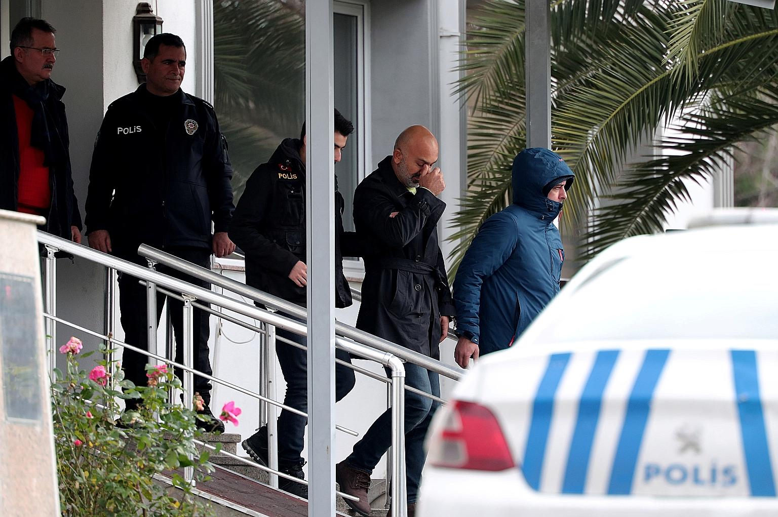 Two people suspected of helping Carlos Ghosn escape being escorted by Turkish police as they left a police station in Istanbul yesterday.