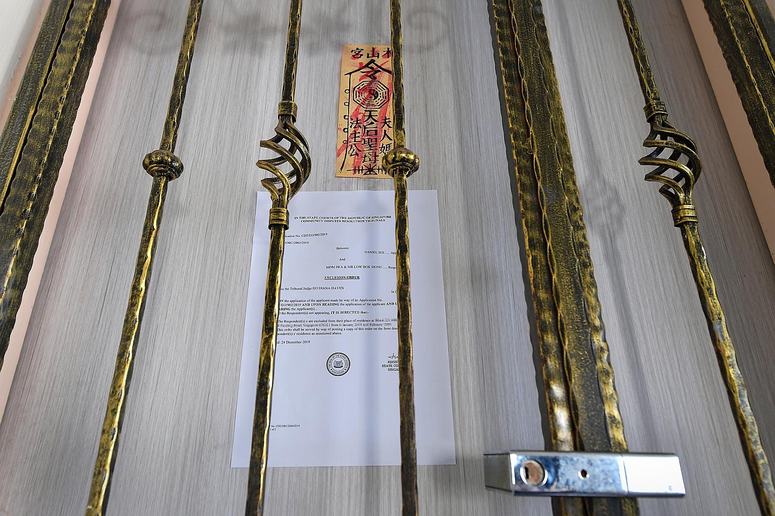 An Exclusion Order on the front door of a flat directing Madam Iwa and Mr Low Bok Siong to leave their Pending Road residence for a month. ST PHOTO: NG SOR LUAN