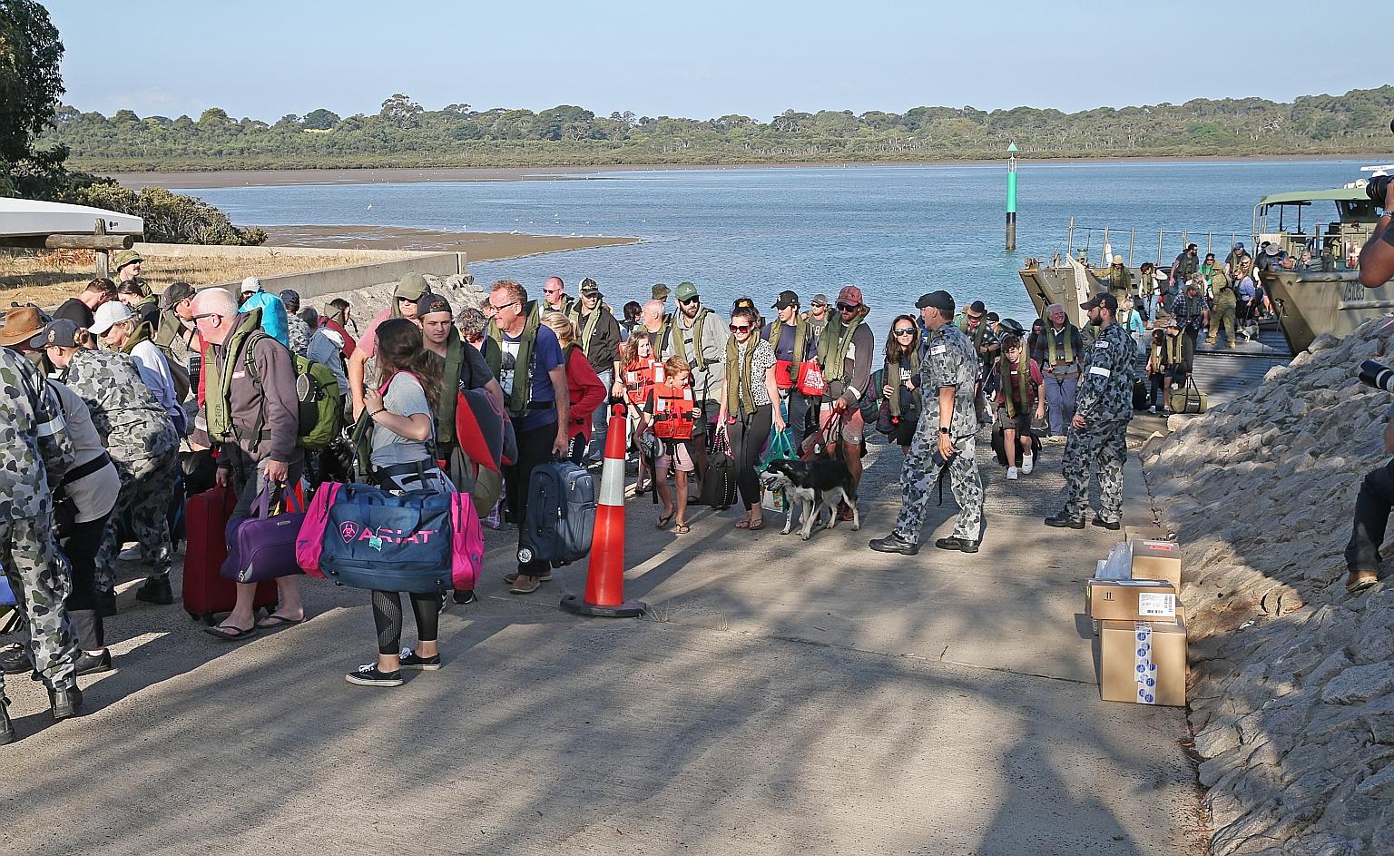 Evacuees from the bush fires landing at Hastings, Victoria, yesterday. Residents of the Australian state's fire-ravaged east are being urged to leave before another heatwave raises the bush fire danger tomorrow. PHOTO: EPA-EFE