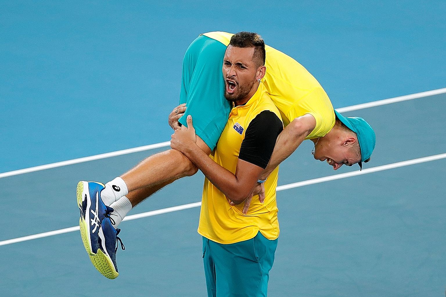 Australia's Nick Kyrgios carrying Alex de Minaur off the court following their 2-1 quarter-final win over Britain yesterday. They will play Belgium or Spain in the semi-finals on Saturday. PHOTO: REUTERS