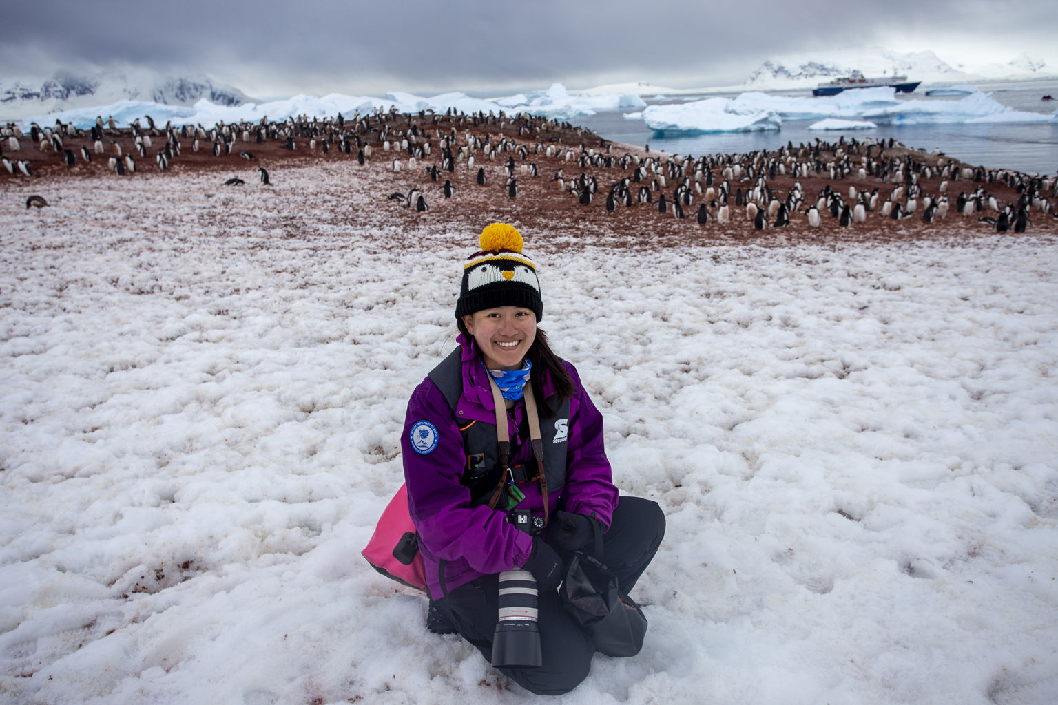 Ms Adelene Cheng with a colony of gentoo penguins at Cuverville Island.
