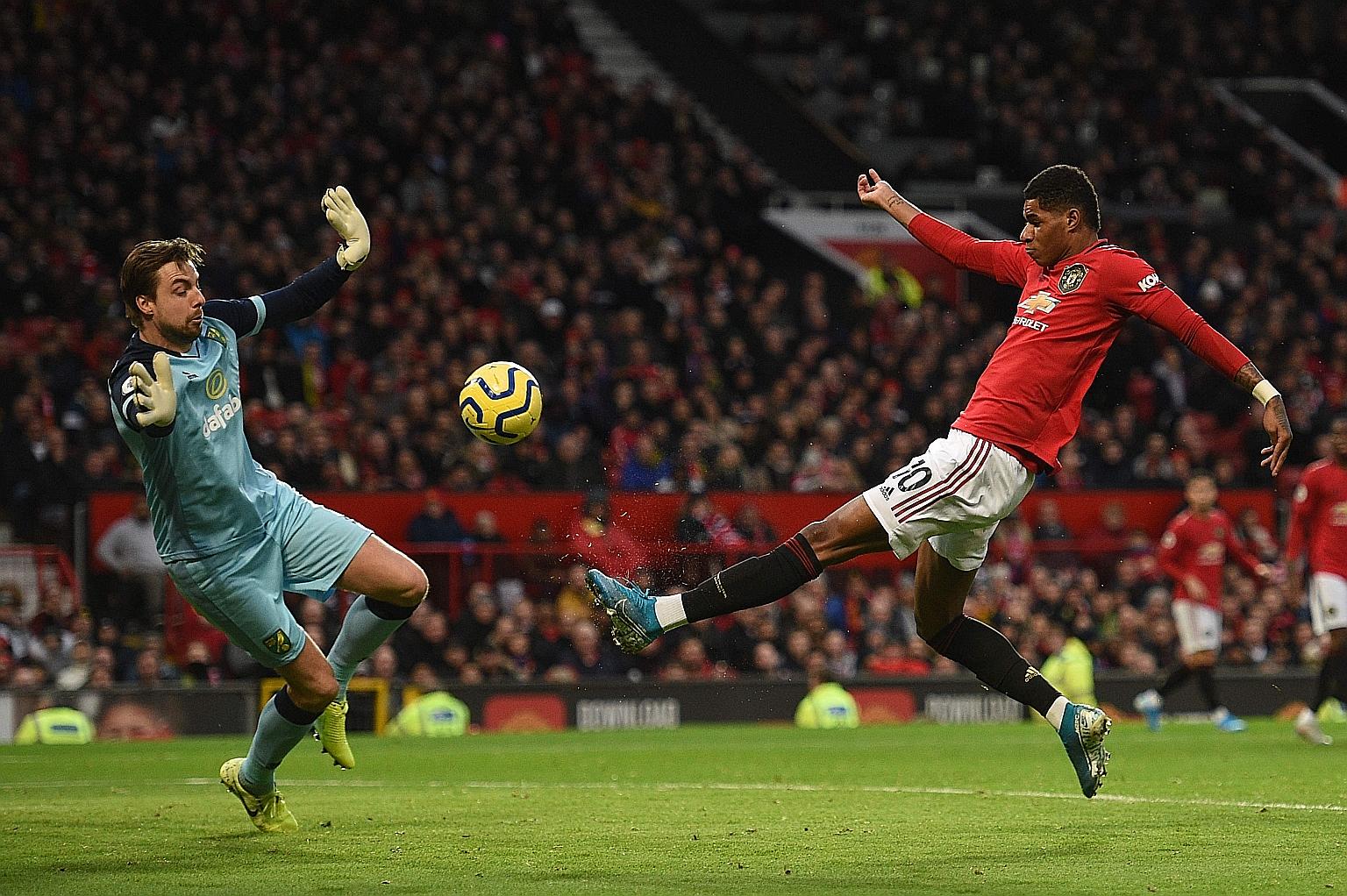 Manchester United striker Marcus Rashford scoring the opener against Norwich's Tim Krul on Saturday. In his 200th game for United, the 22-year-old added a second from the spot to reach 19 goals this season. 