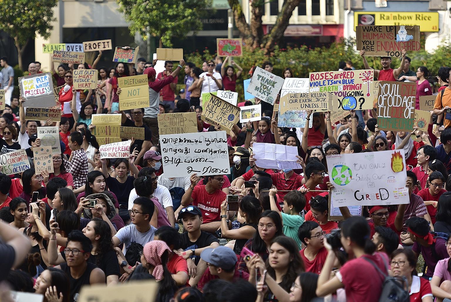 Above: Participants at the Singapore Climate Rally, a movement calling for more action to slash emissions in Singapore, in Hong Lim Park on Sept 21 last year. Right: Ms Loretta Sze, dressed in scuba-diving gear, at the same rally. Greenwatch spokesma