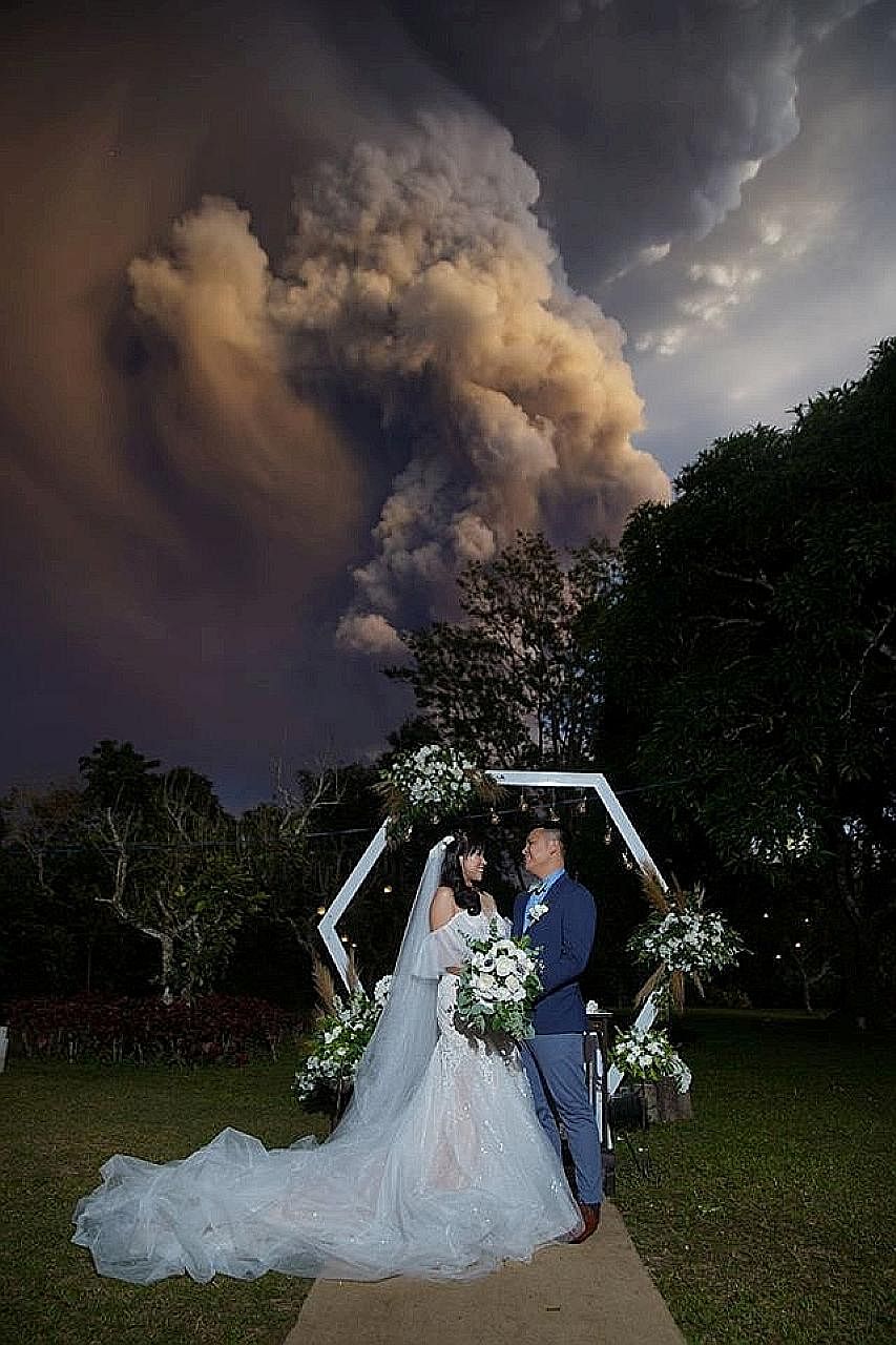 Filipinos Chino and Kat Palomar exchanged vows in Cavite province on Sunday under a huge cloud of smoke and ash from Taal.