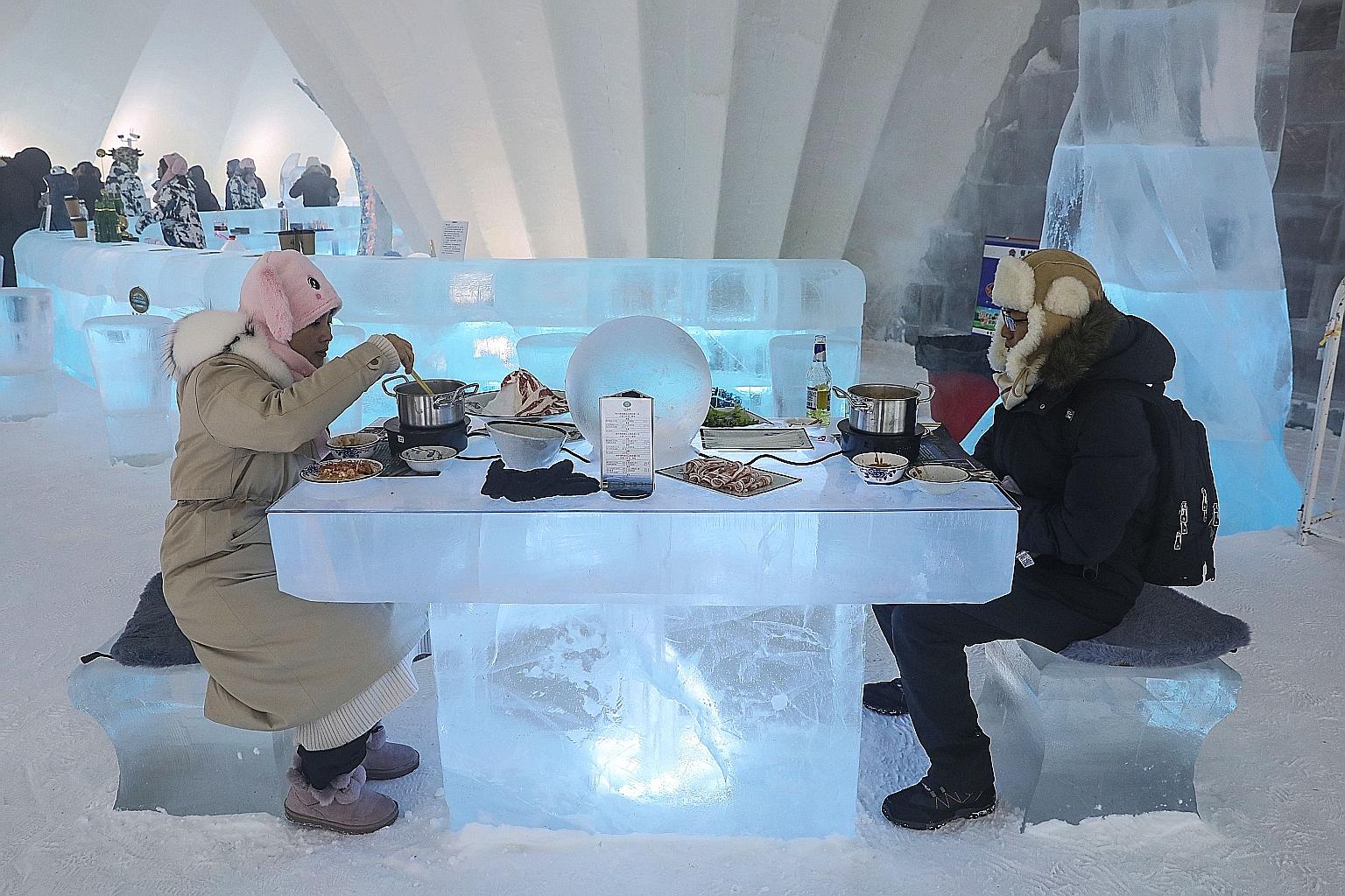 People enjoying hotpot inside an igloo in Harbin in China's north-eastern Heilongjiang province, during the annual Harbin International Ice and Snow Festival. The festival, featuring glittering palaces and fantastical scenes sculpted out of ice, has 